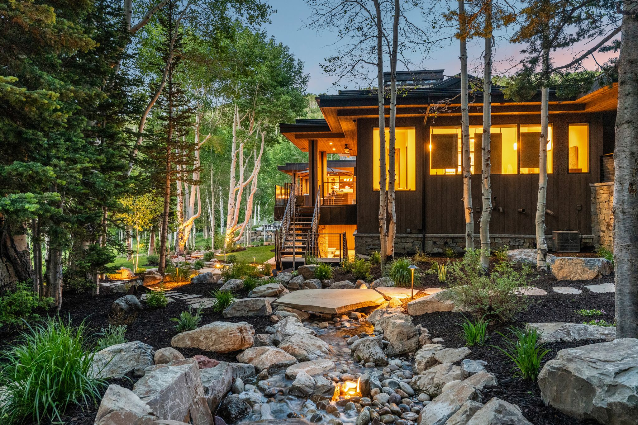 Modern architectural residence with dark wood siding and stone accents