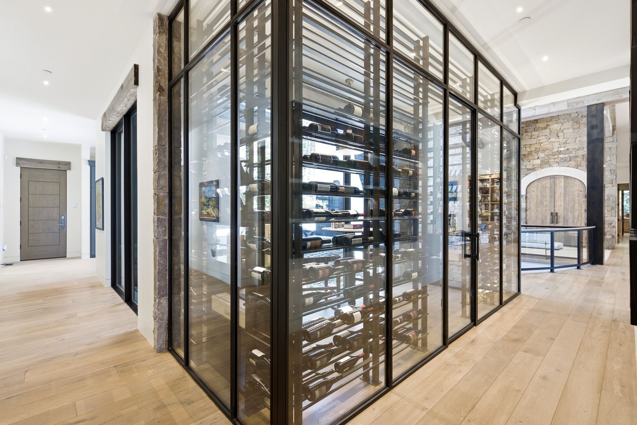 Custom wine cellar with black metal and glass enclosure