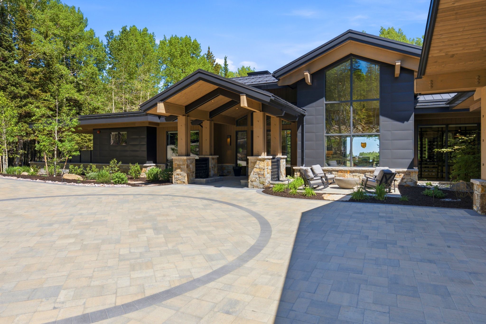 Contemporary architectural design featuring expansive glass, dark siding, and natural wood accents