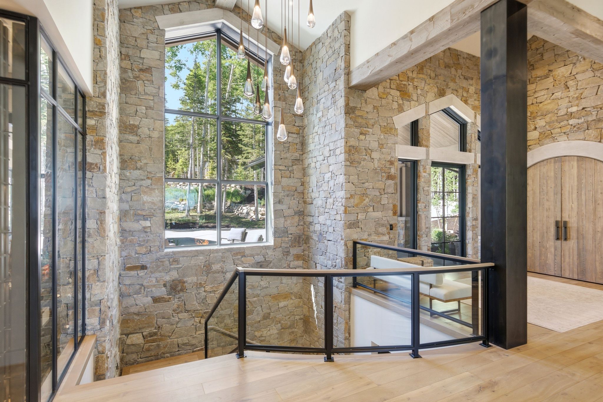 Grand staircase featuring glass railings and wood-finish flooring
