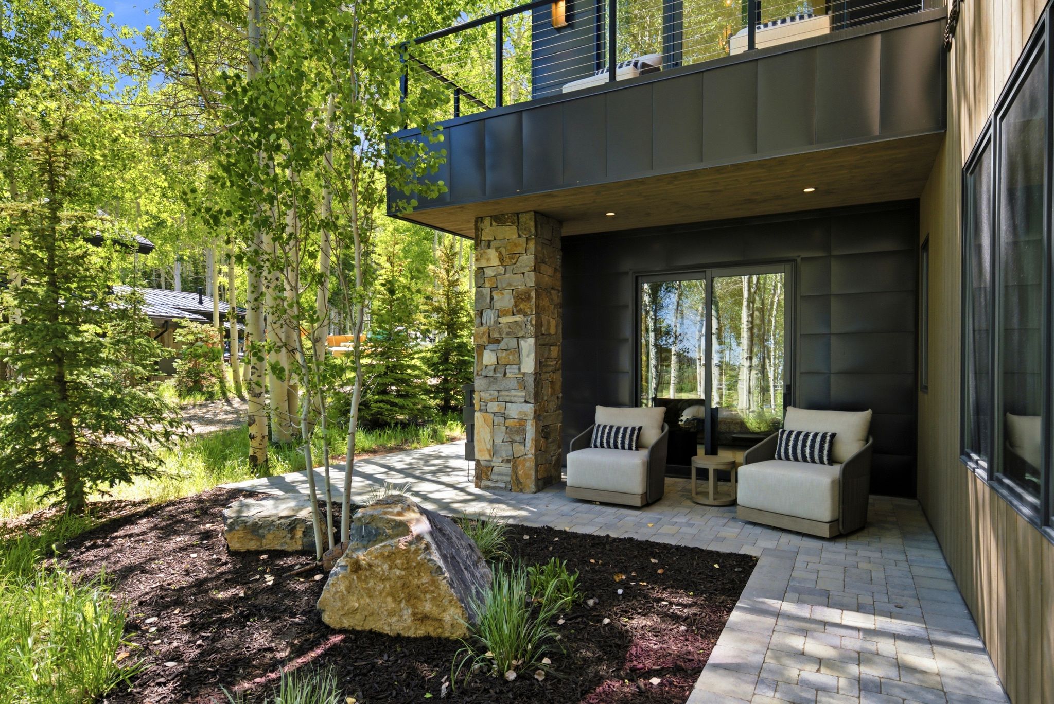 Patio with paver flooring, stone column detailing, and sliding glass door access
