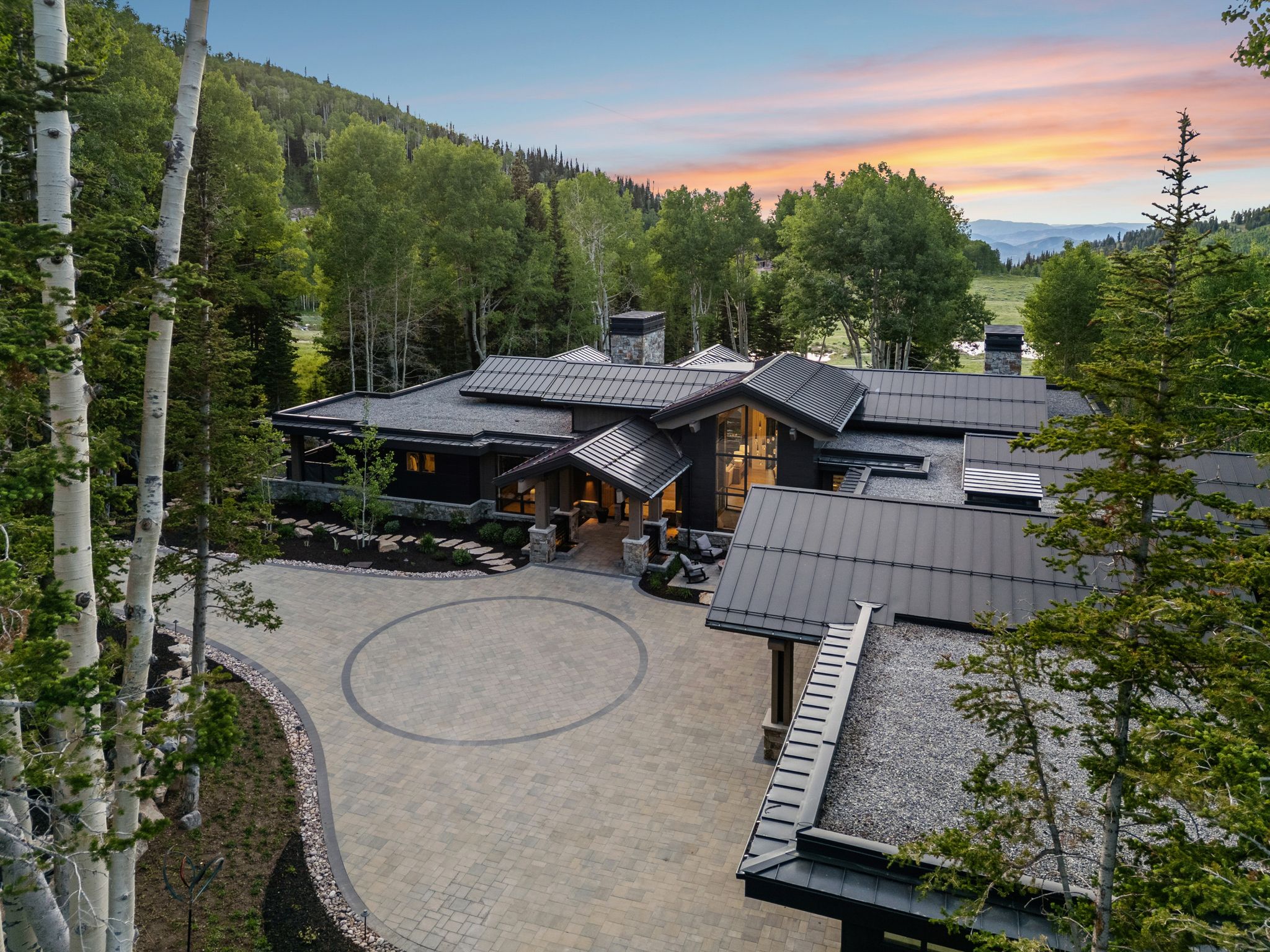 Modern mountain architectural style with dark siding and a prominent metal roof