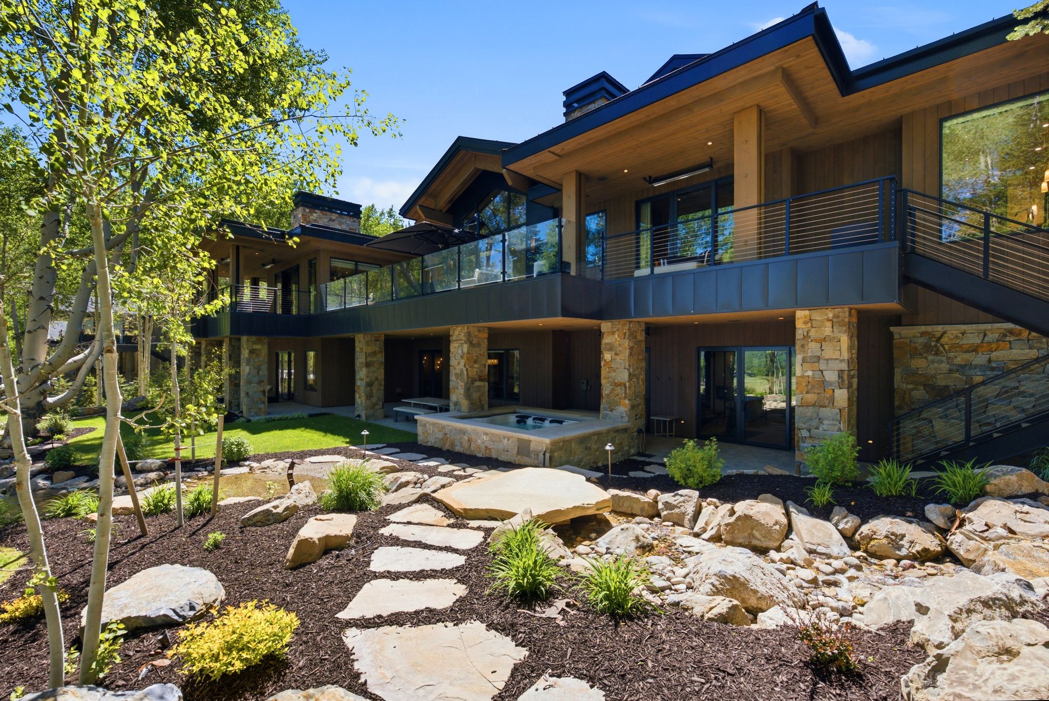 Expansive multi-level residence featuring wood-finish siding and stone accents
