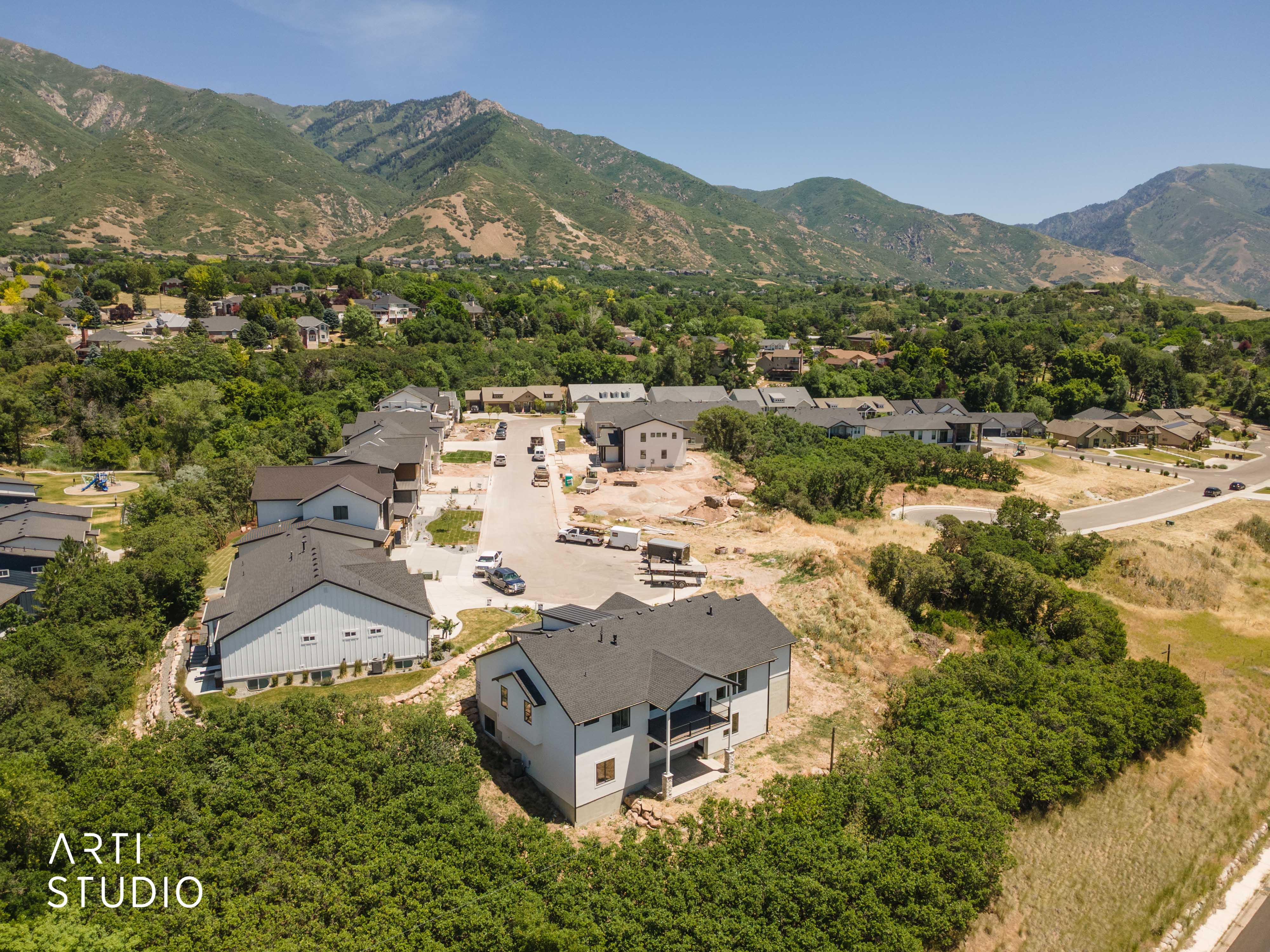 Newly constructed residential development featuring modern homes with dark roofs and light siding