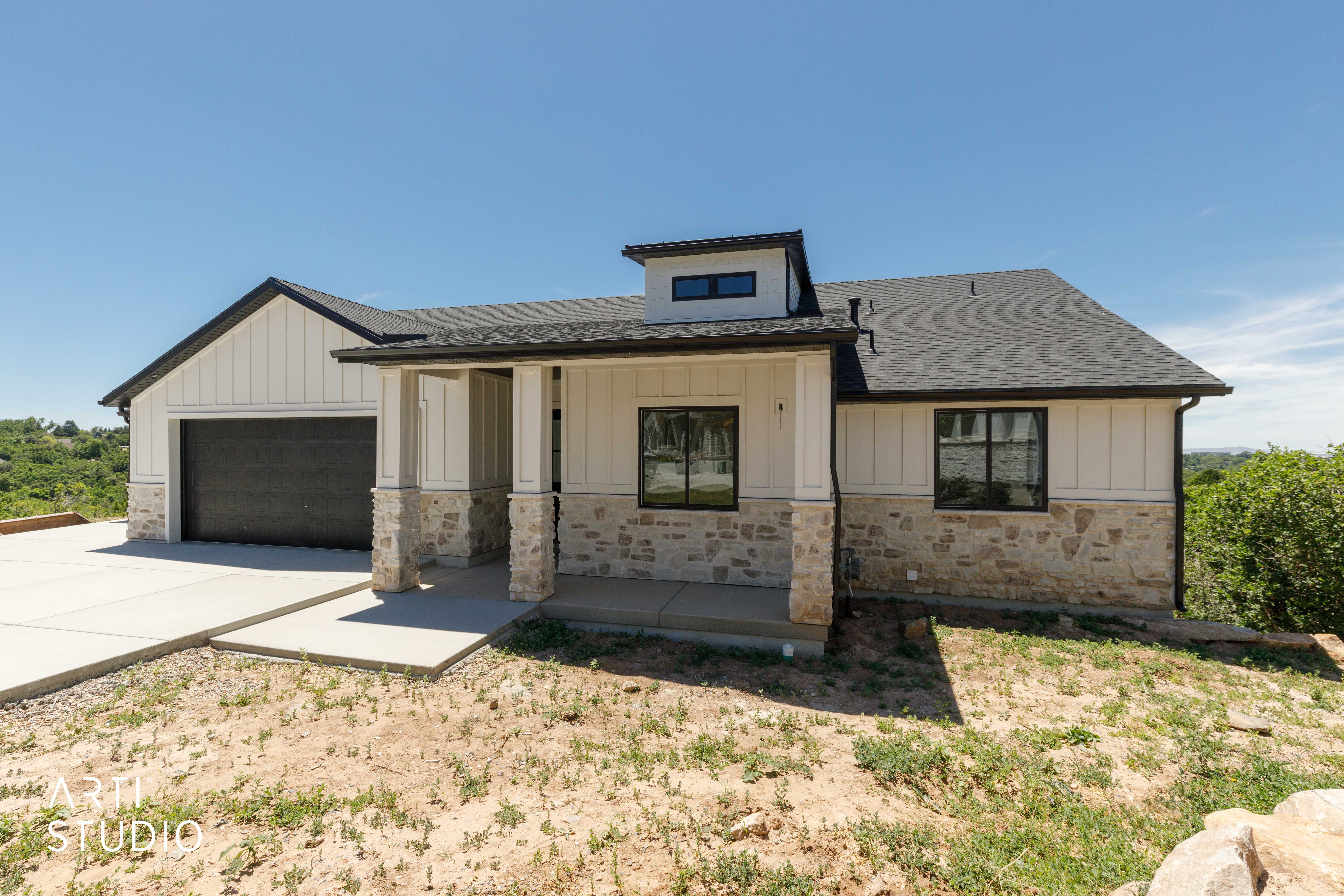 Modern ranch-style home featuring a stone and vertical siding facade