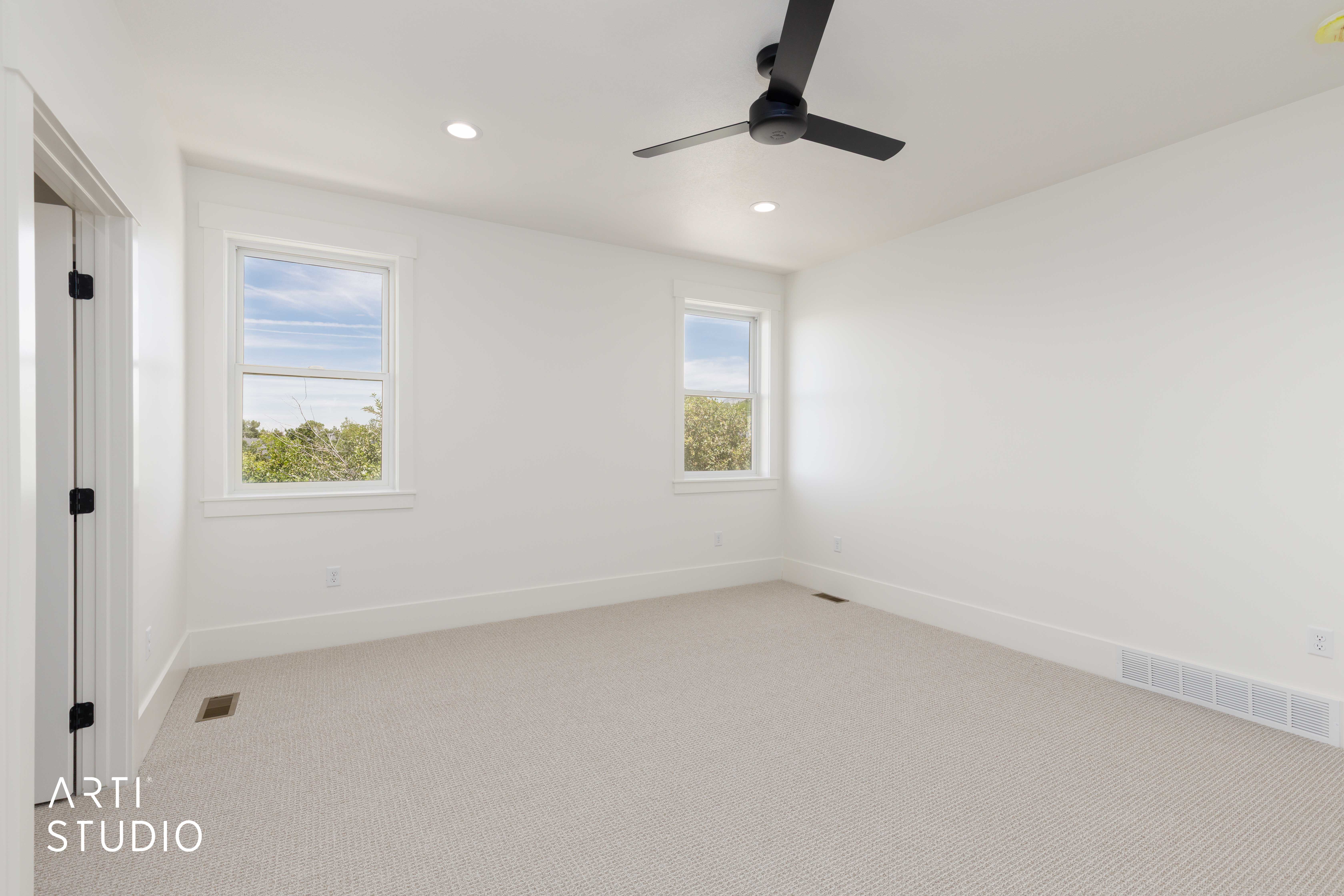 Neutral-toned carpeting complements the white walls and trim in this room