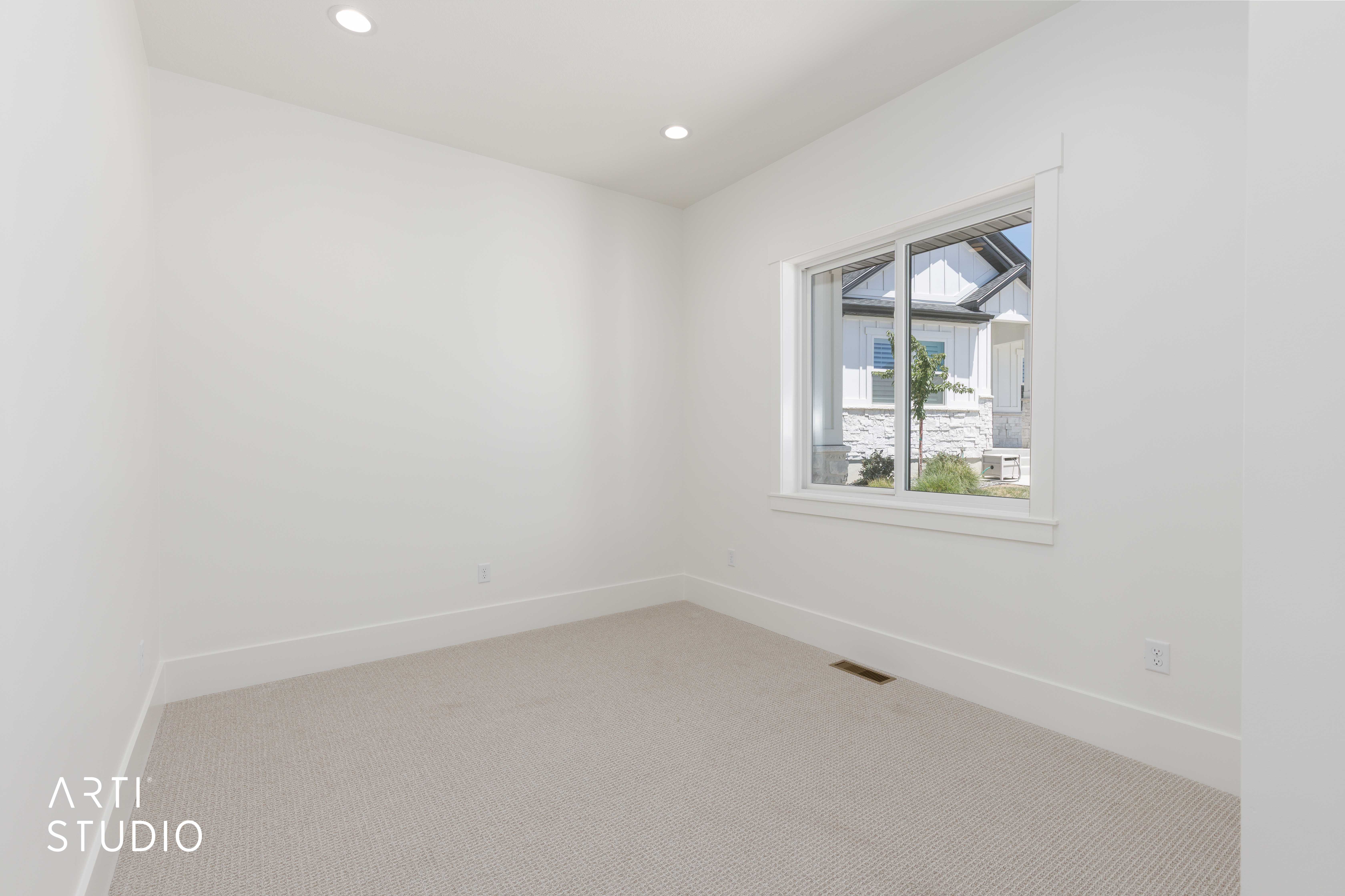 Bright room featuring recessed lighting, a large window with white trim, and light-colored carpeting