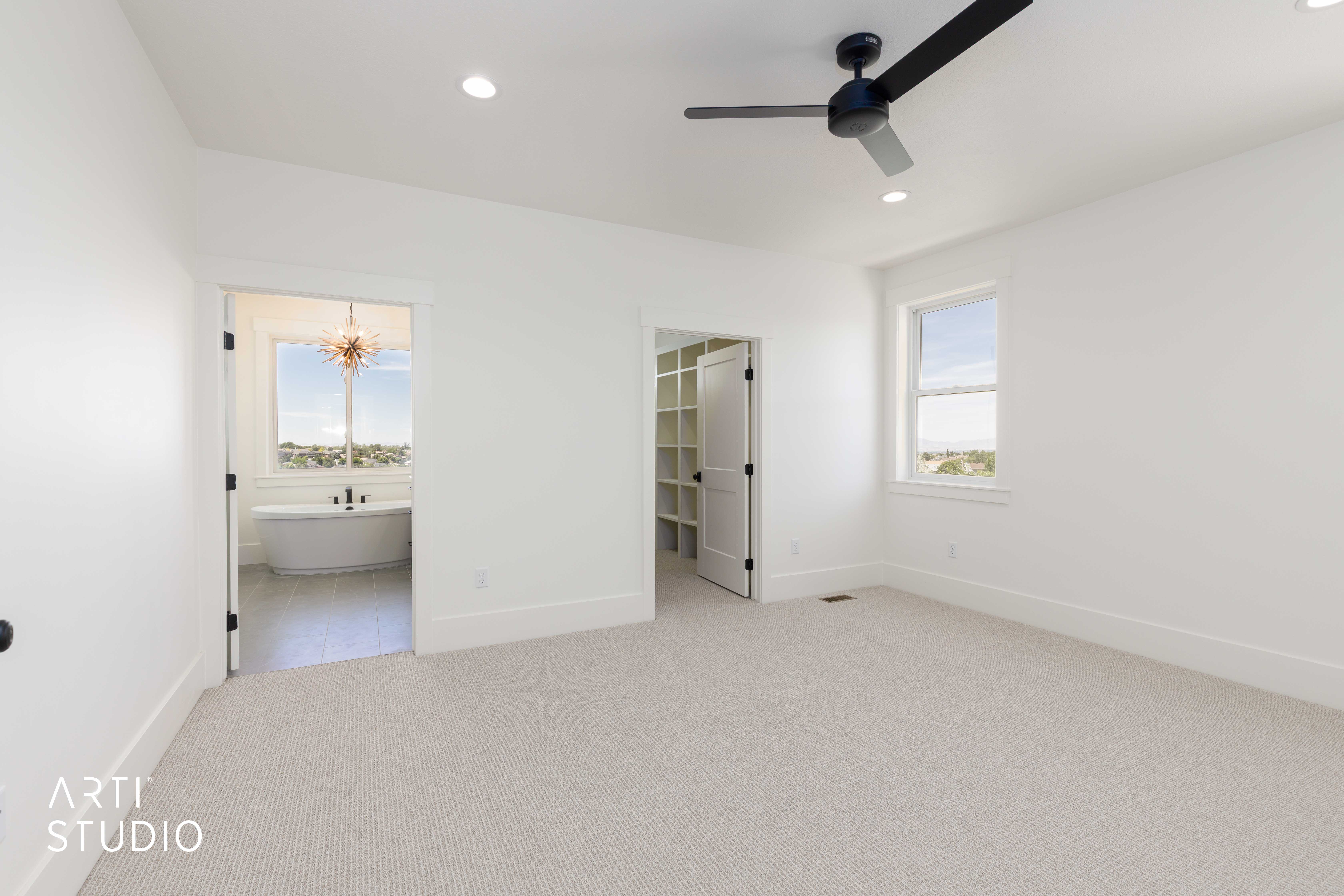 Spacious room with light-colored carpeting and white walls