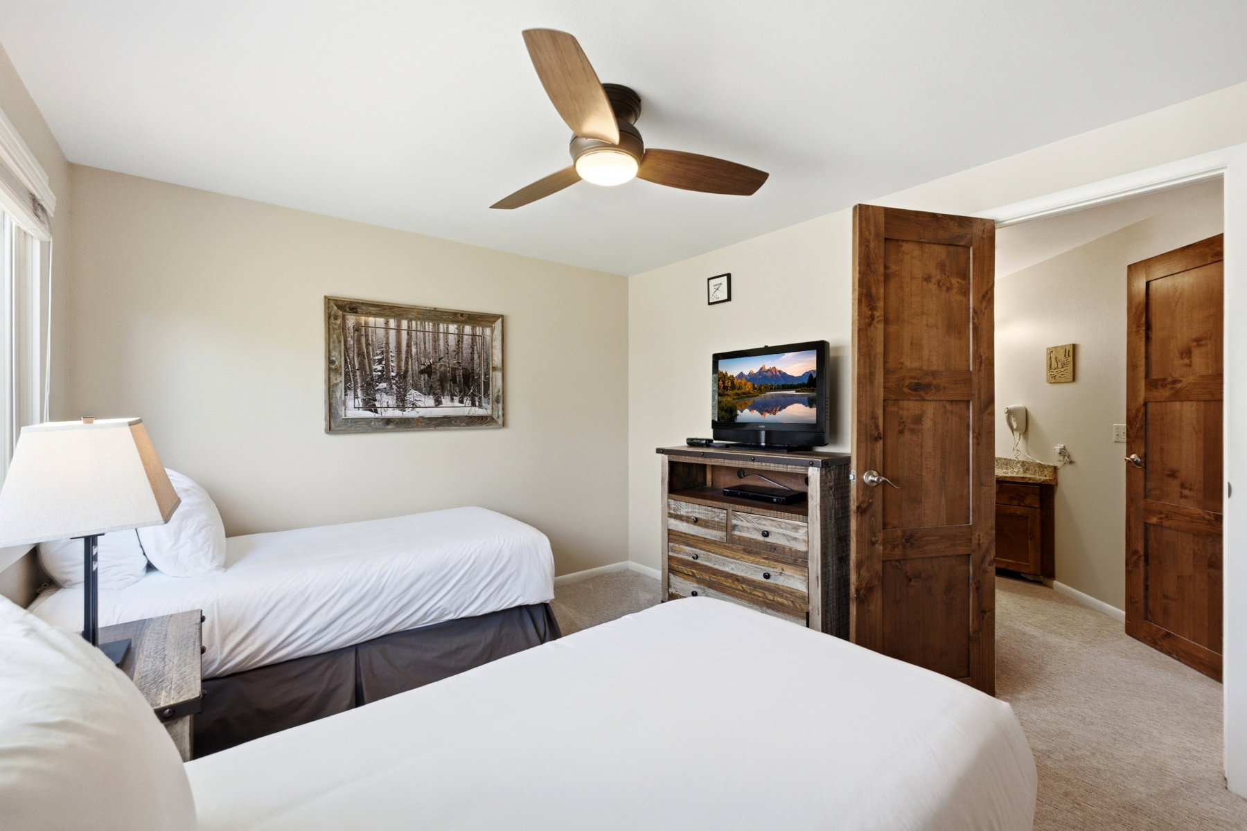 Neutral wall paint with a wood-finish ceiling fan and recessed lighting