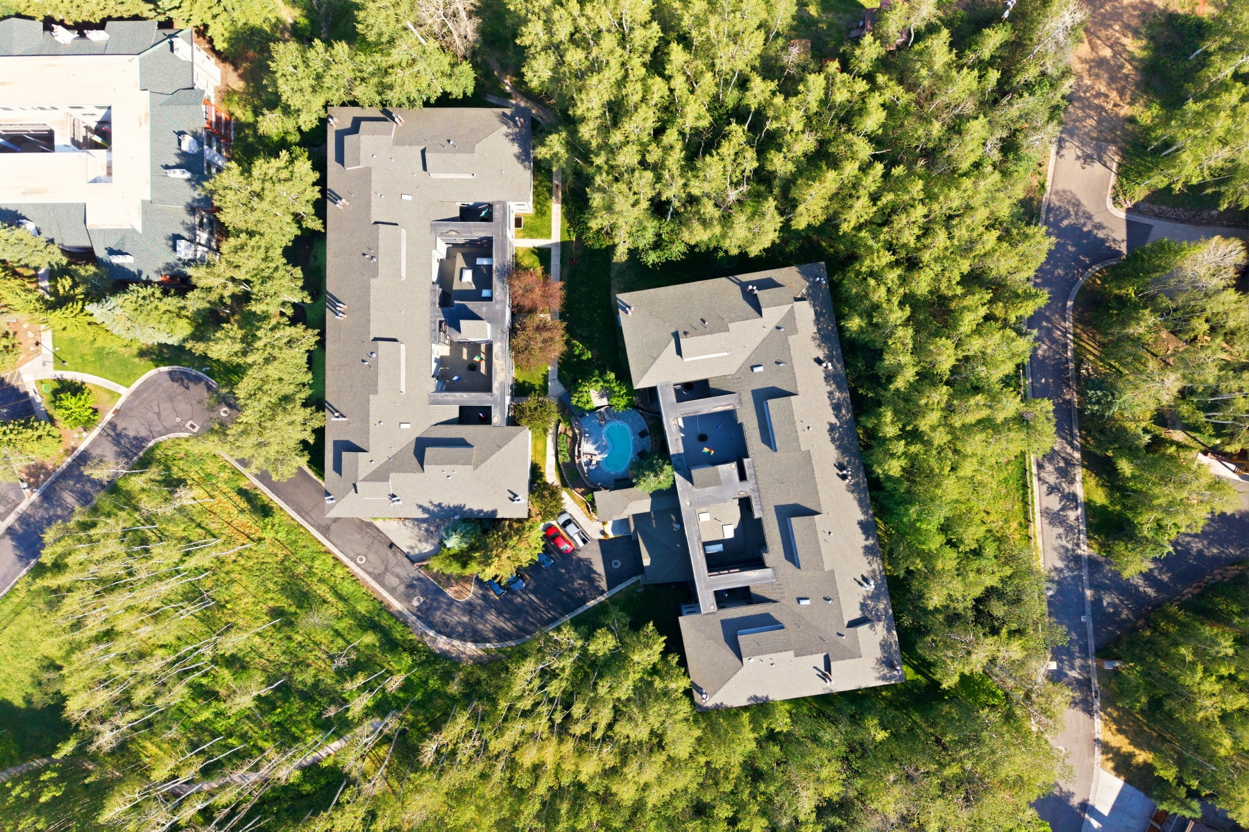 Aerial perspective showcasing two multi-unit structures with dark gray roofing