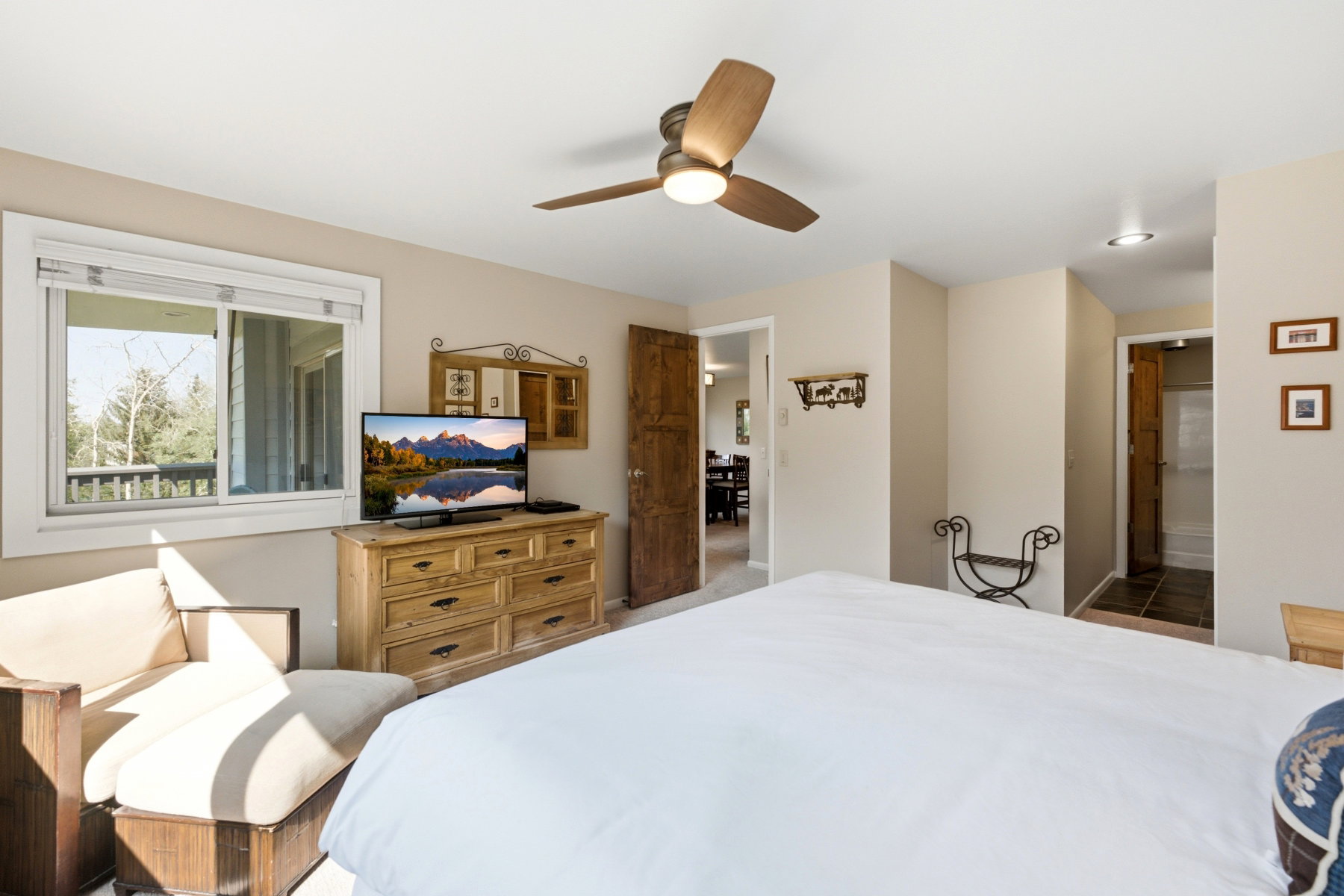 Bedroom featuring a ceiling fan with integrated lighting, recessed lighting, and a window with a wooded backdrop
