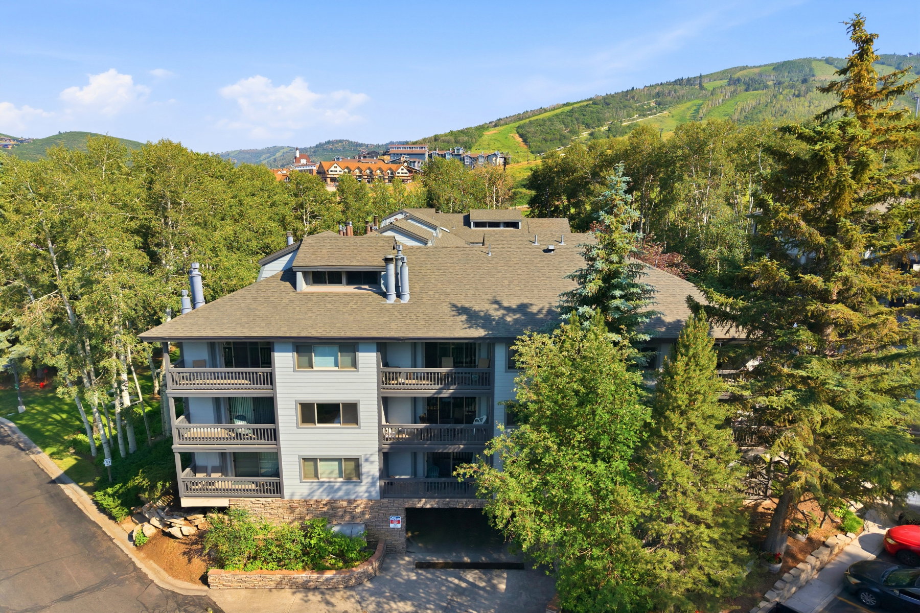 Multi-story residential building with light gray siding and dark trim