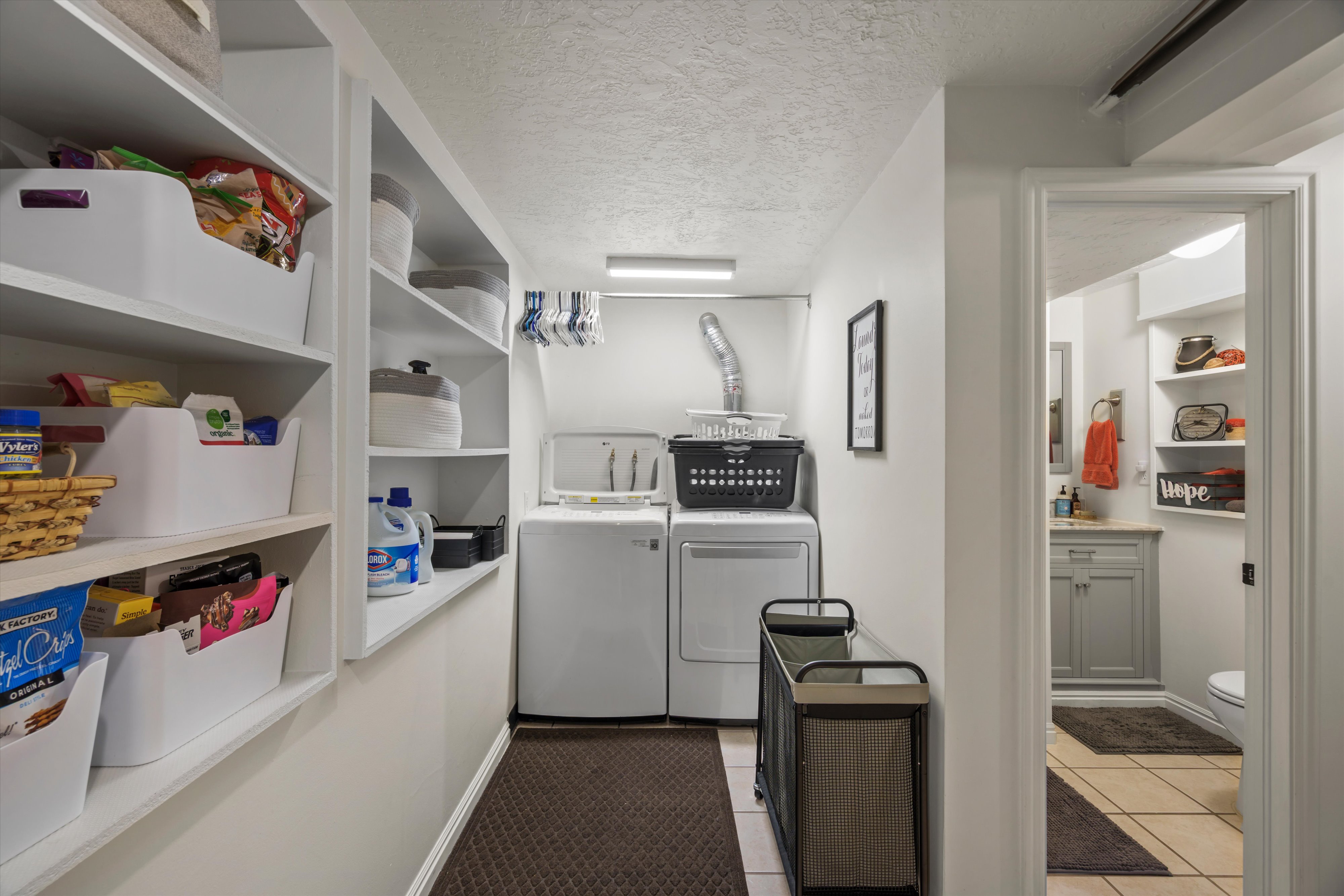 Dedicated laundry area with pantry like shelving.