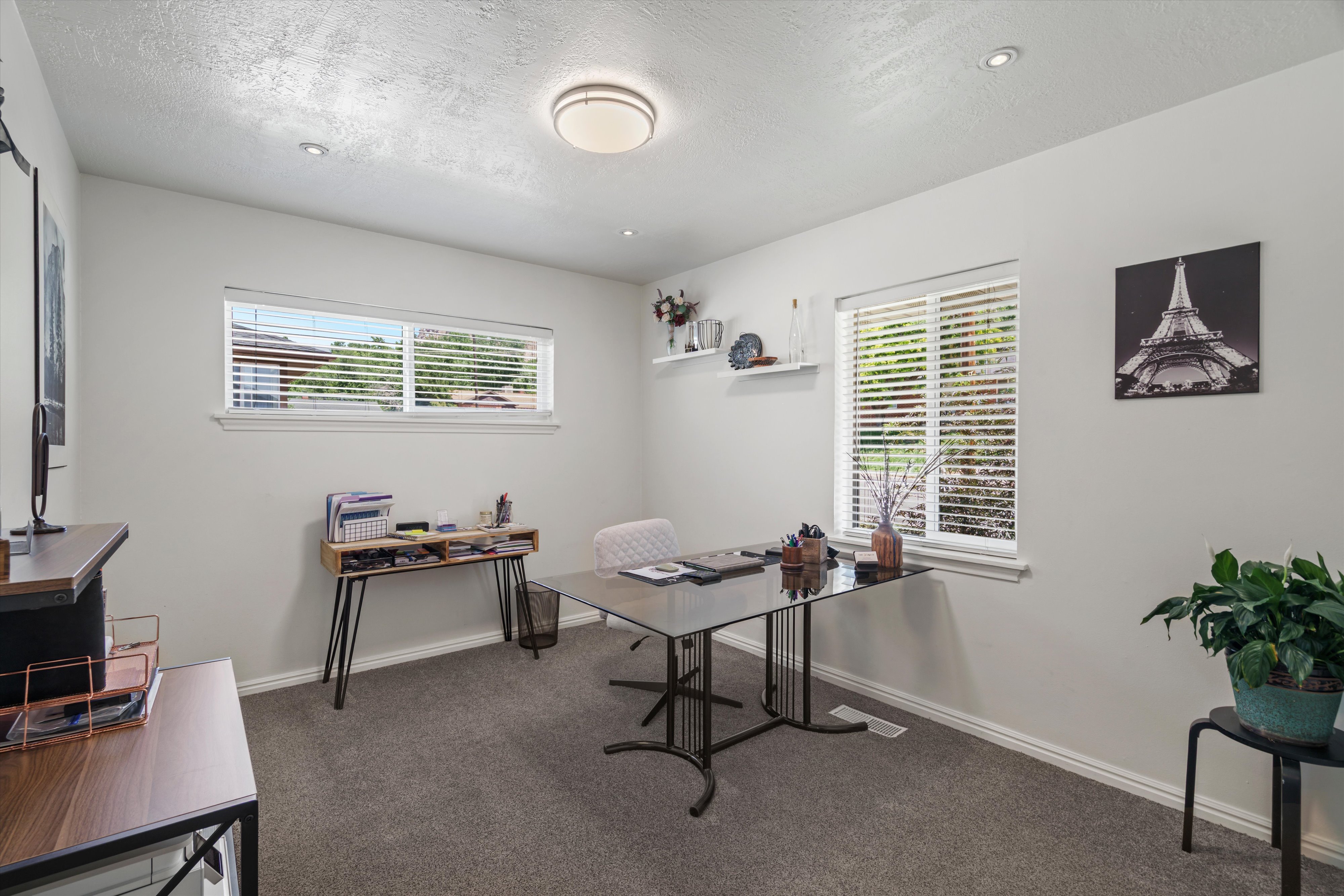 Interior room featuring dual windows with horizontal blinds, providing natural illumination