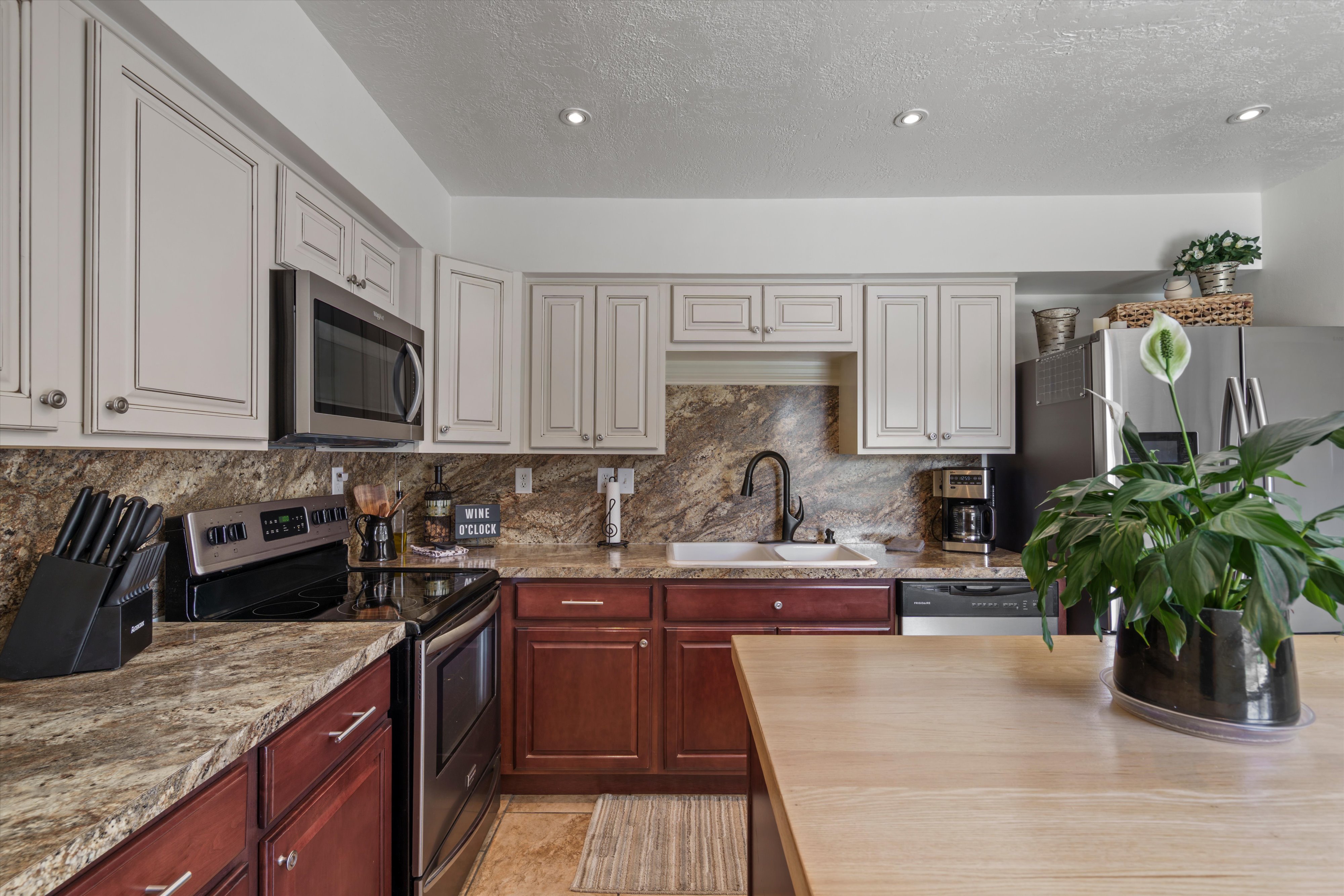 Kitchen featuring two-tone cabinetry, stainless steel appliances, and recessed lighting