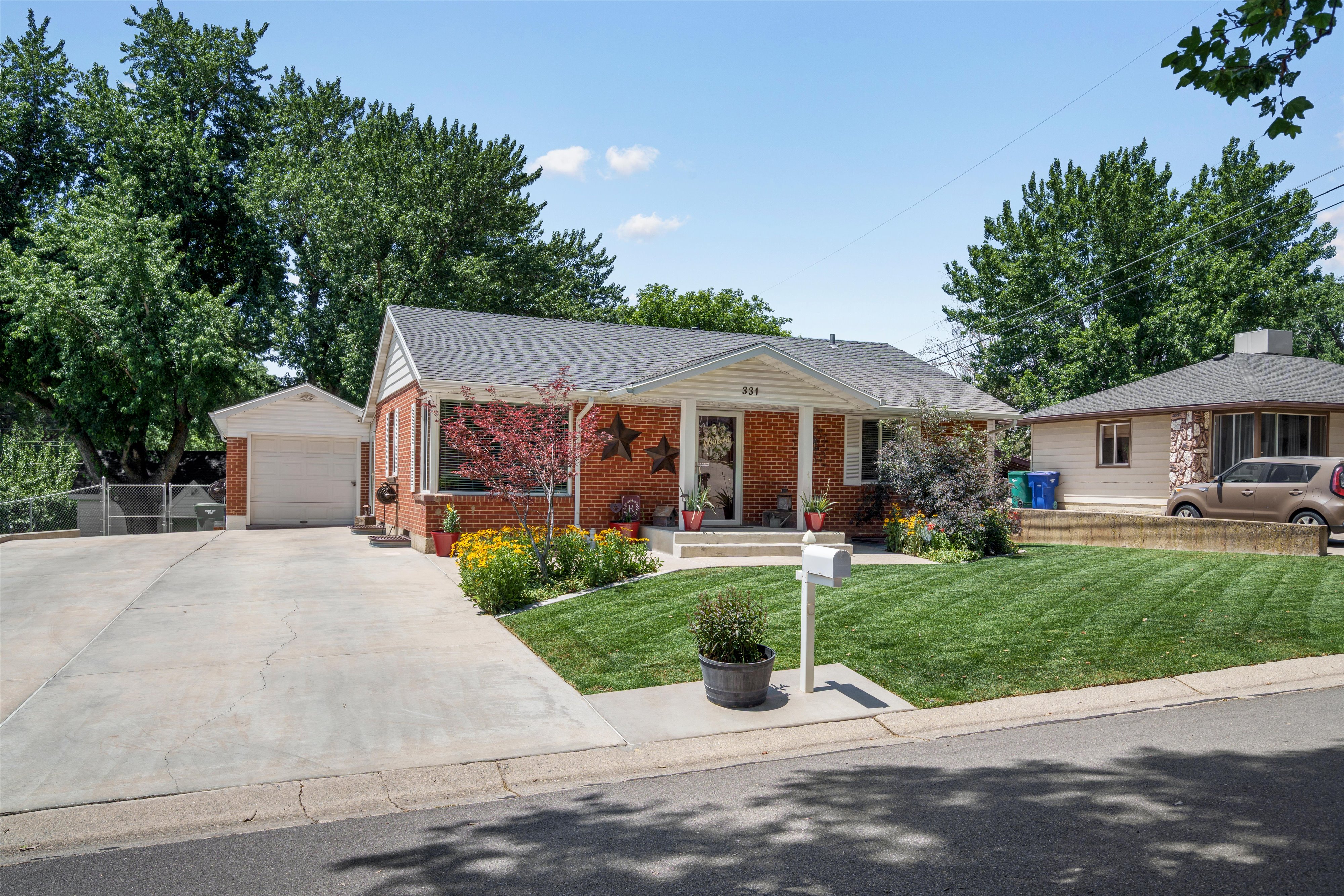 Brick residence featuring a covered front porch, white siding details, and a dark shingle roof