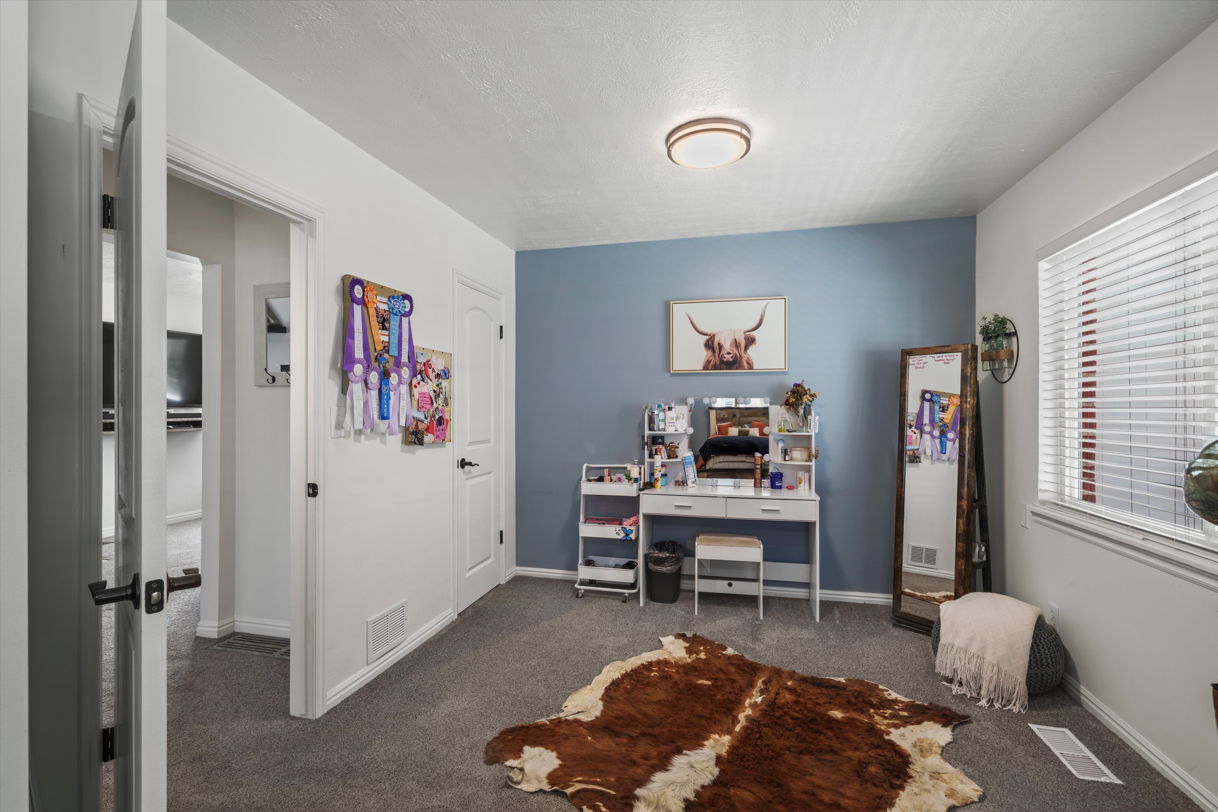 Spacious room featuring carpeting, a window with blinds, and white trim