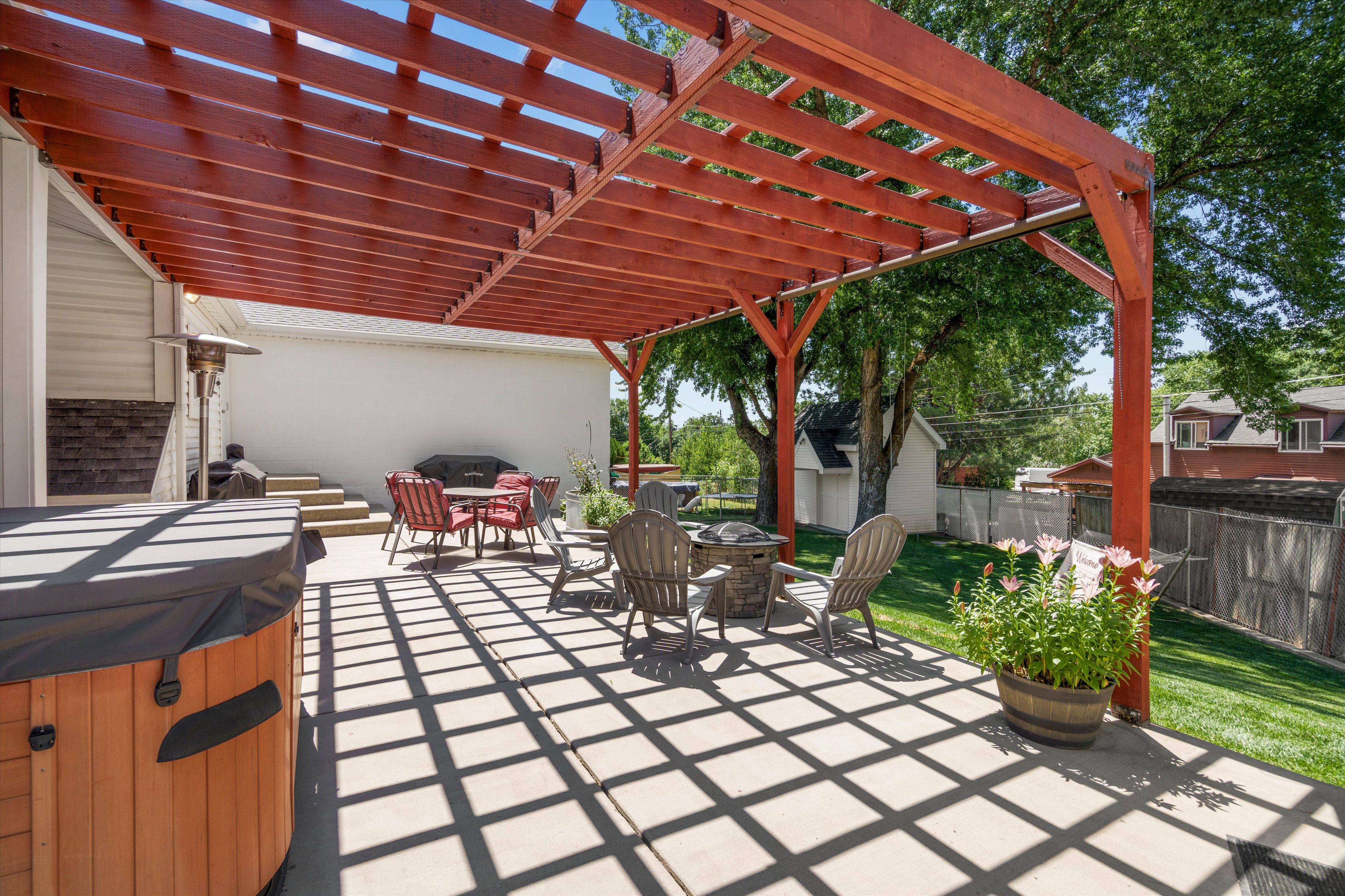 Expansive concrete patio with a wooden pergola structure