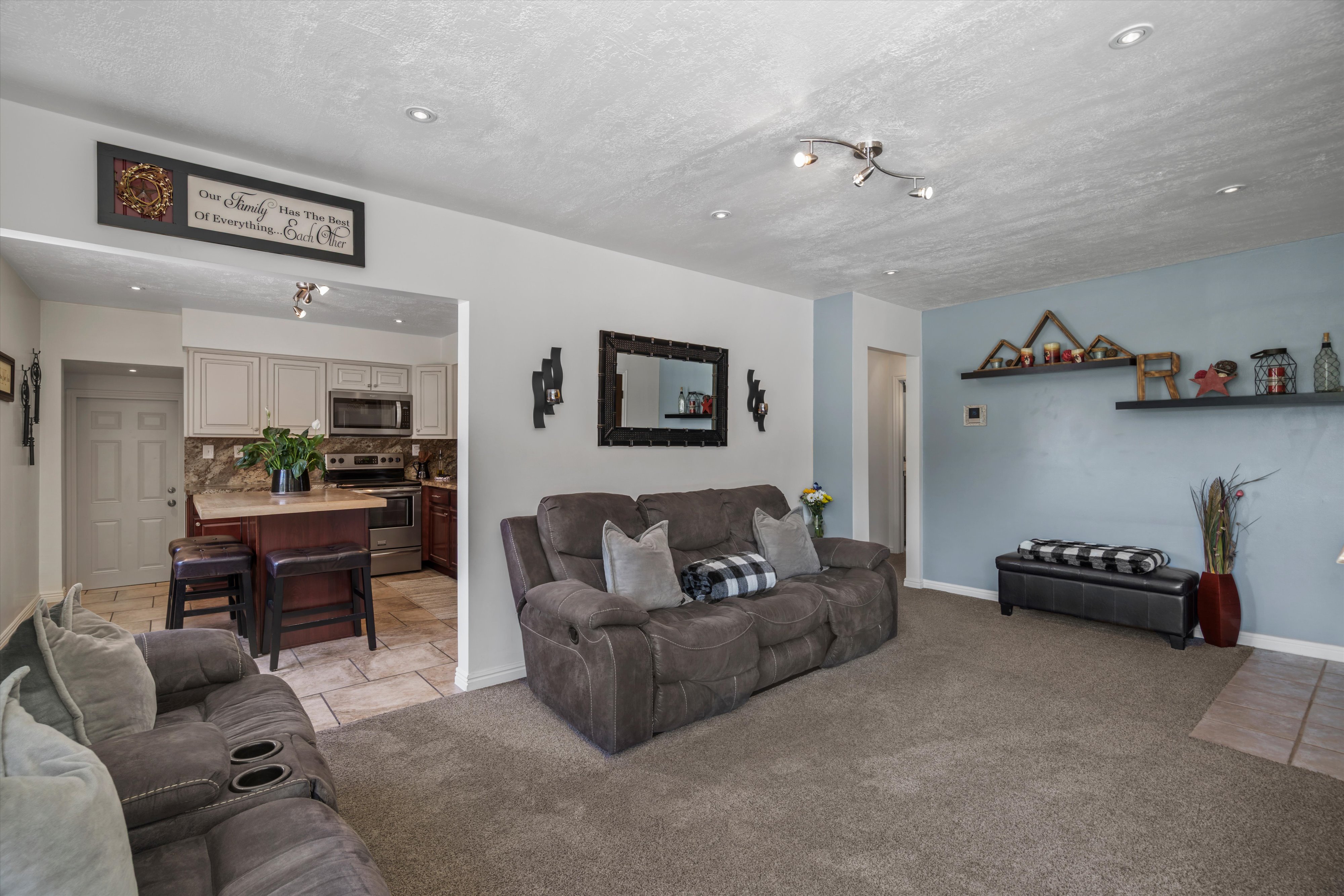 Living area featuring carpet flooring, recessed lighting, and a light blue accent wall
