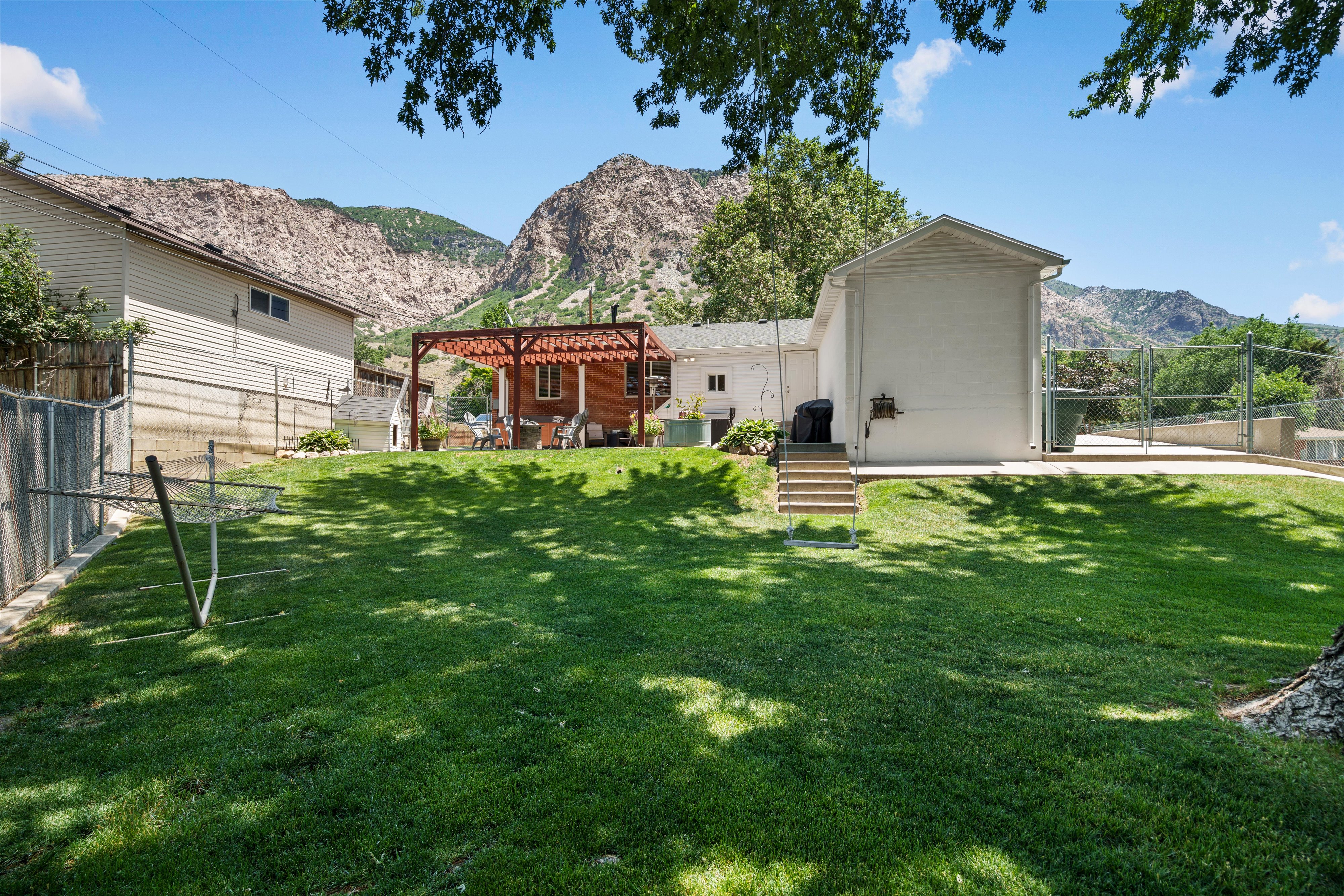 Expansive grassy yard with mature trees providing shade