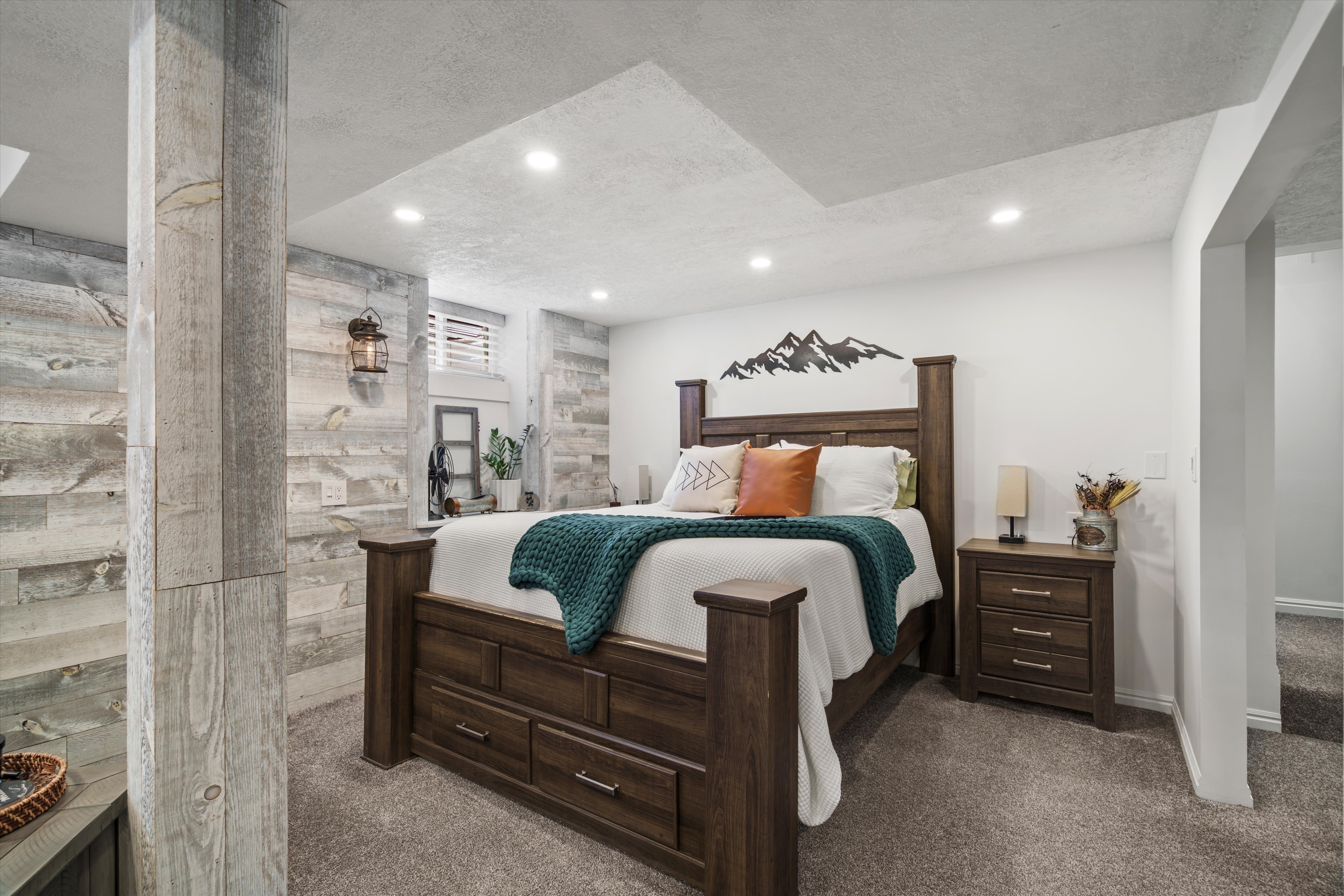 Primary bedroom or family room featuring a shiplap accent wall, built-in recessed lighting, and a window with horizontal blinds