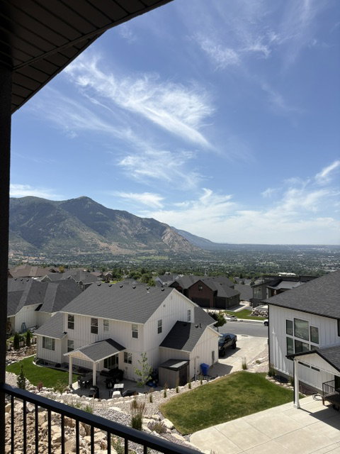 Hillside property featuring expansive mountain scenery and distant cityscape