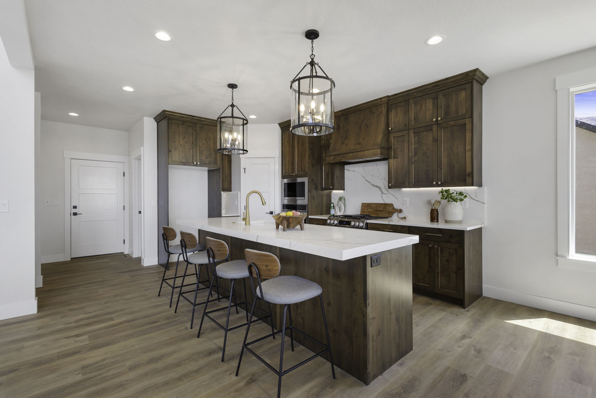 Kitchen featuring a large island with seating, wood-finish flooring, recessed lighting, and dark wood cabinetry