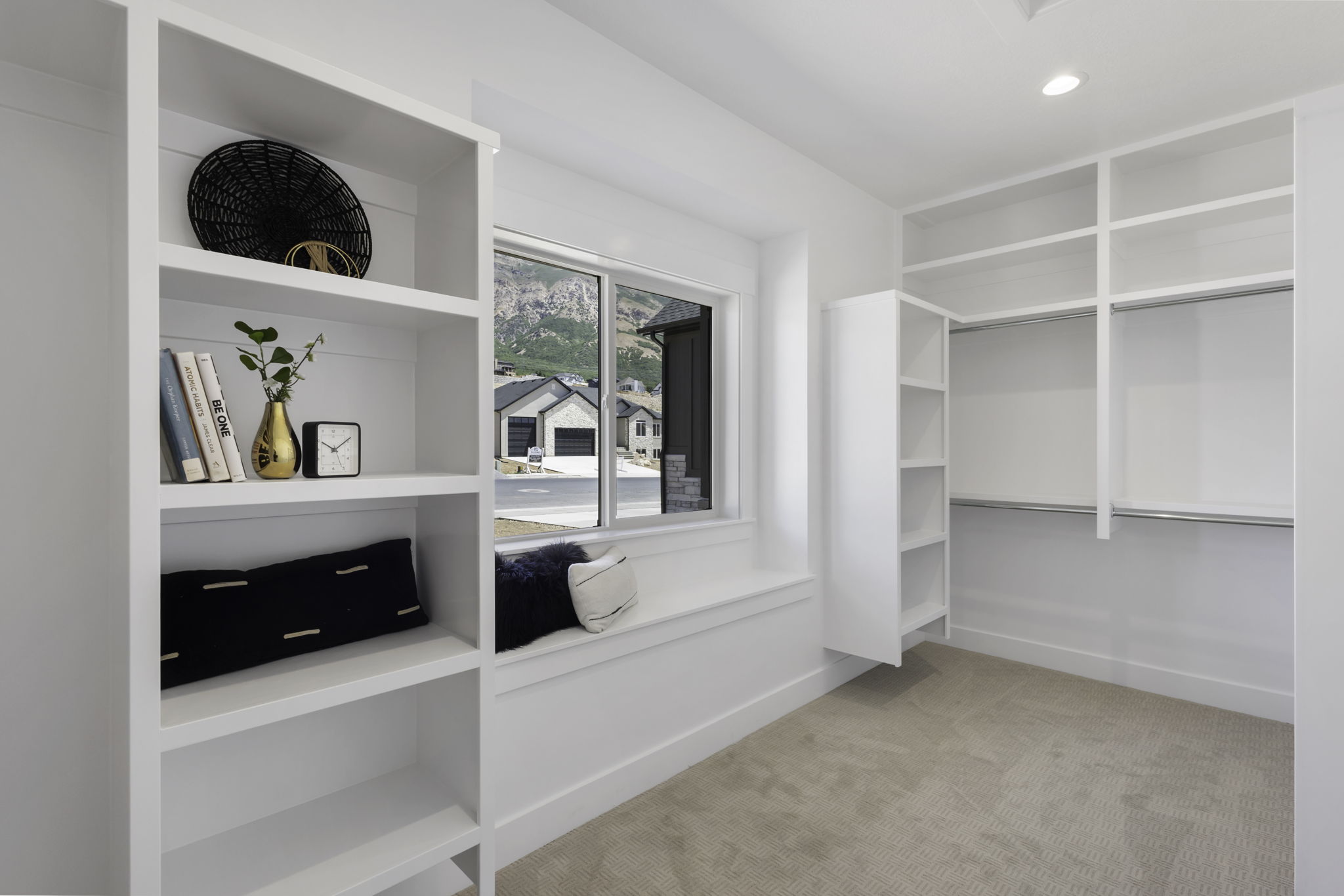 Built-in shelving and closet organization system featuring white finishes and metal hanging rods