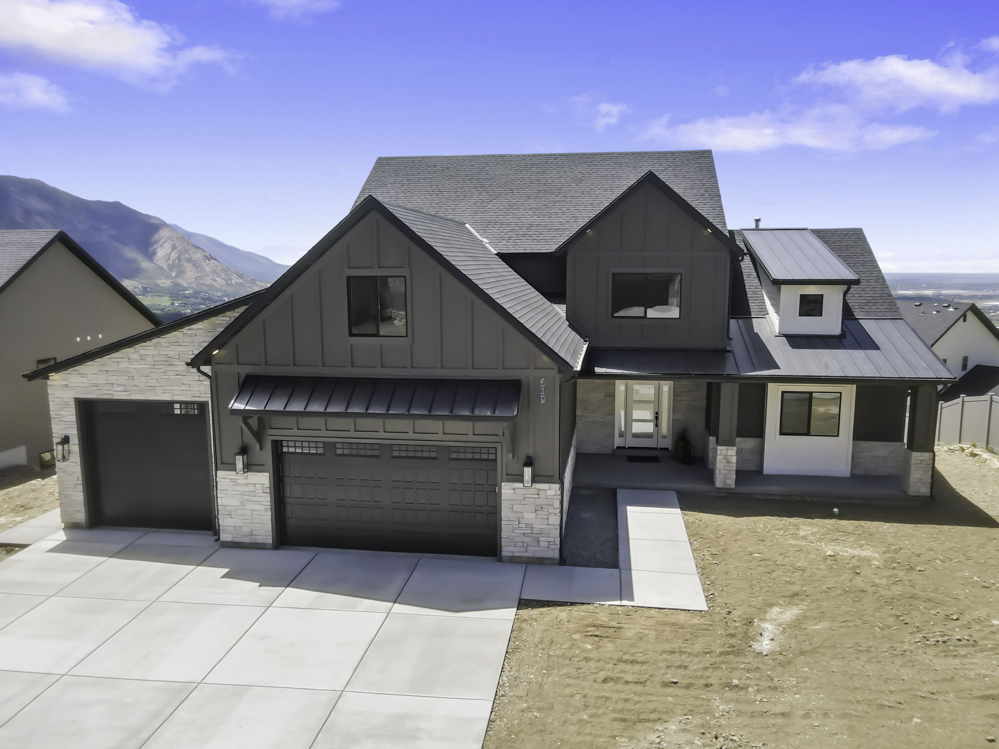 Contemporary exterior featuring vertical siding, stone accents, and a multi-gabled roofline