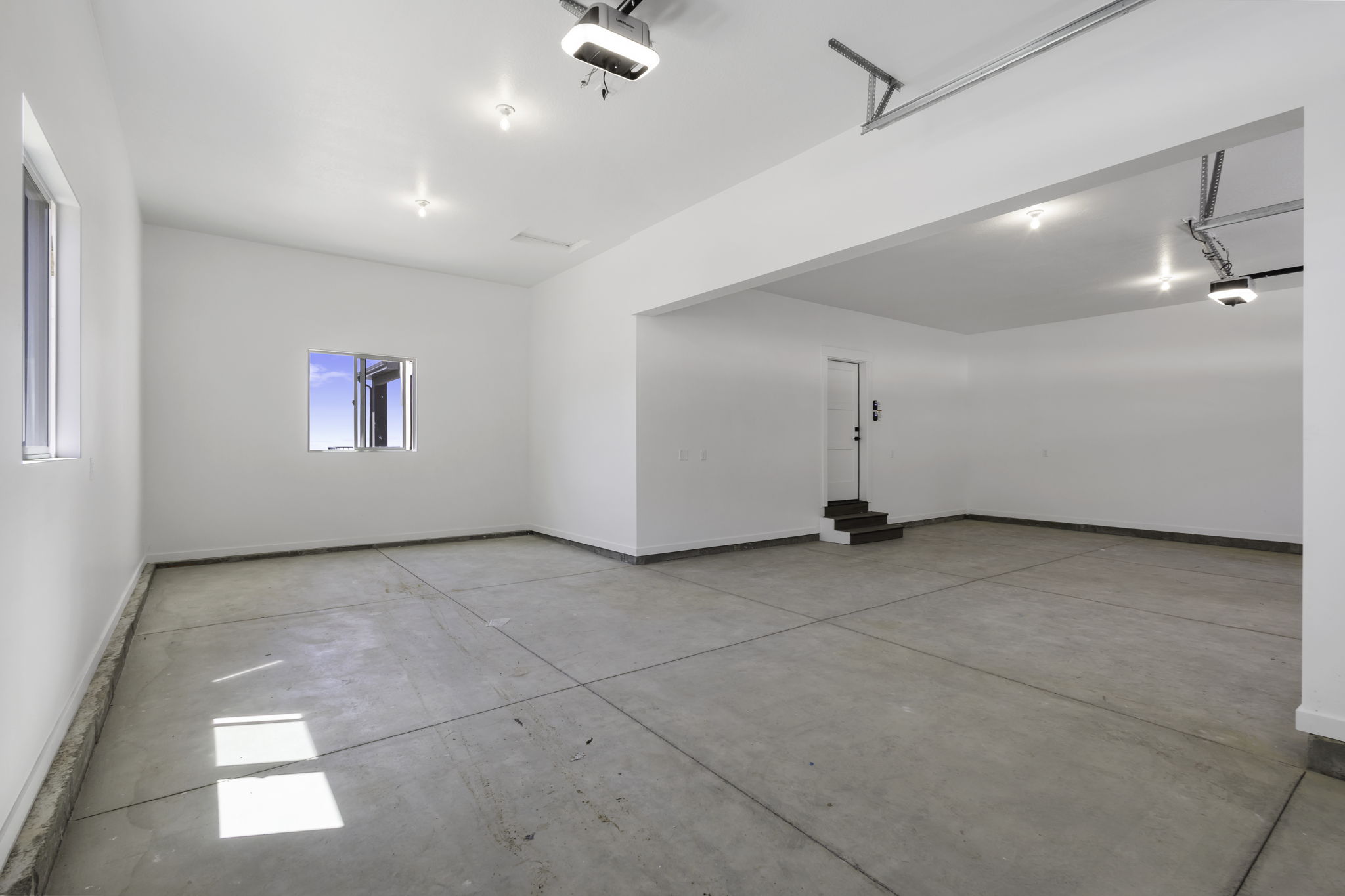 Spacious garage with smooth concrete flooring and bright white walls