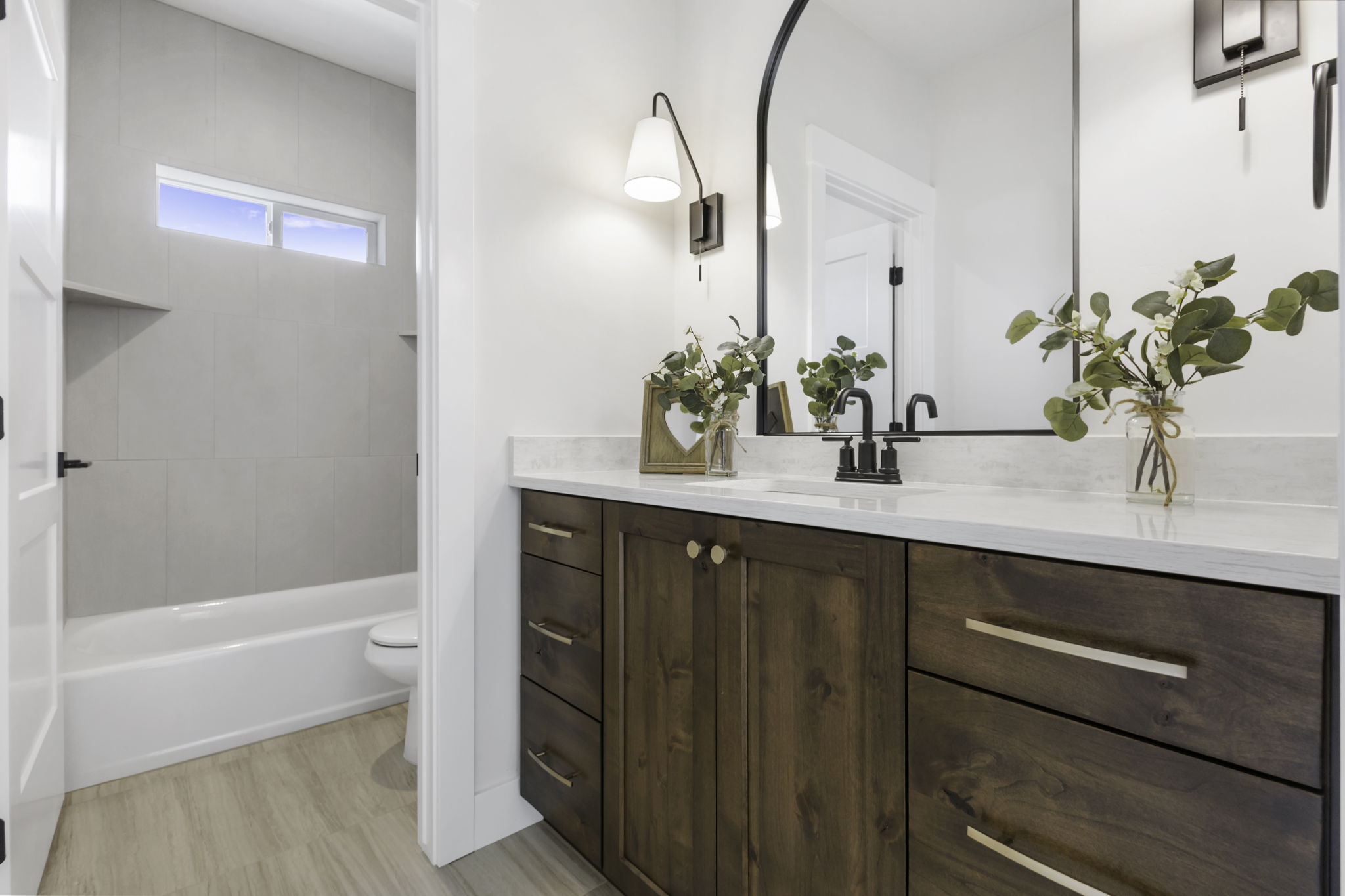 Contemporary bathroom featuring a dark wood-finish vanity with a white countertop and rectangular sink