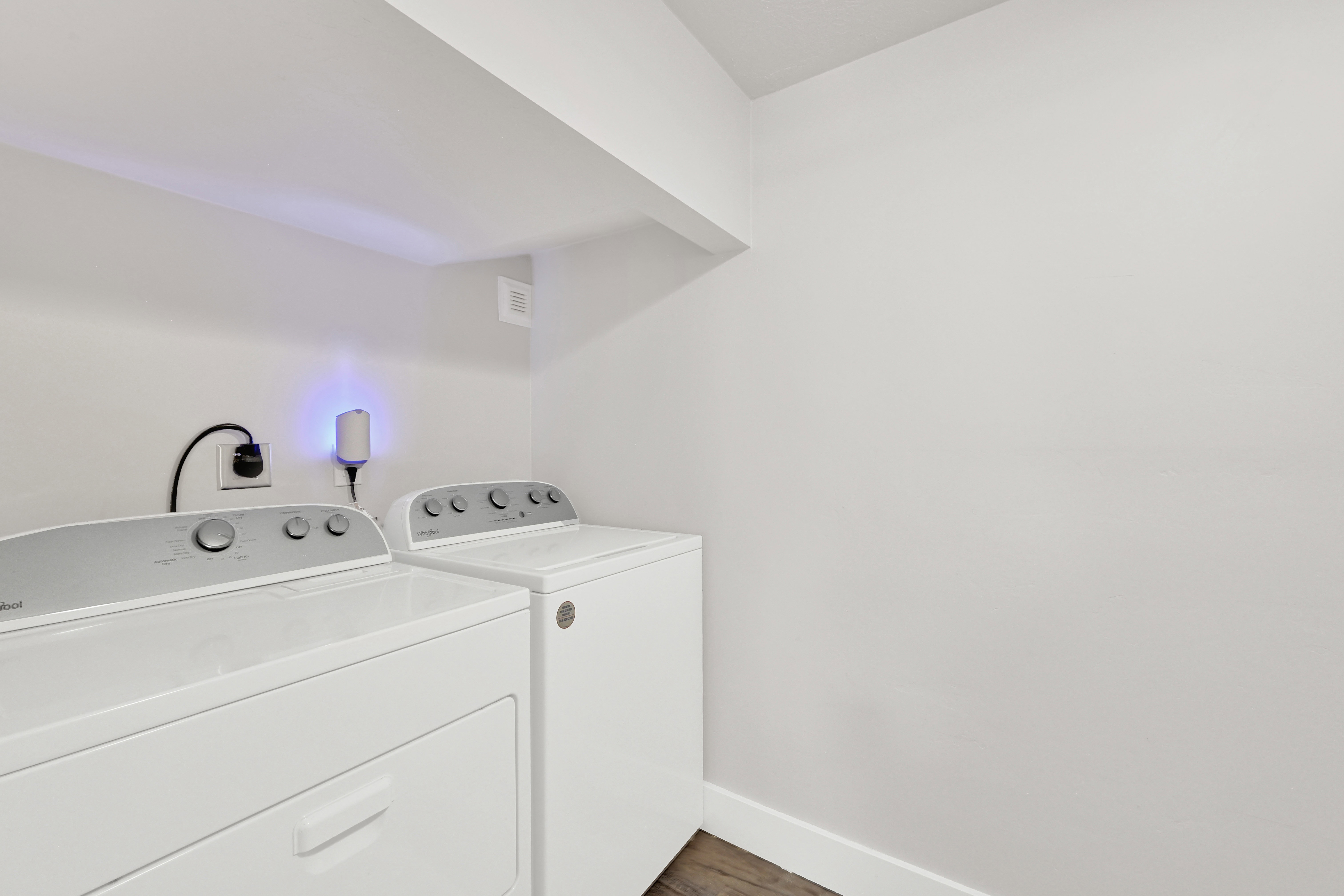 Dedicated laundry area featuring a white top-load washing machine and a white front-load dryer