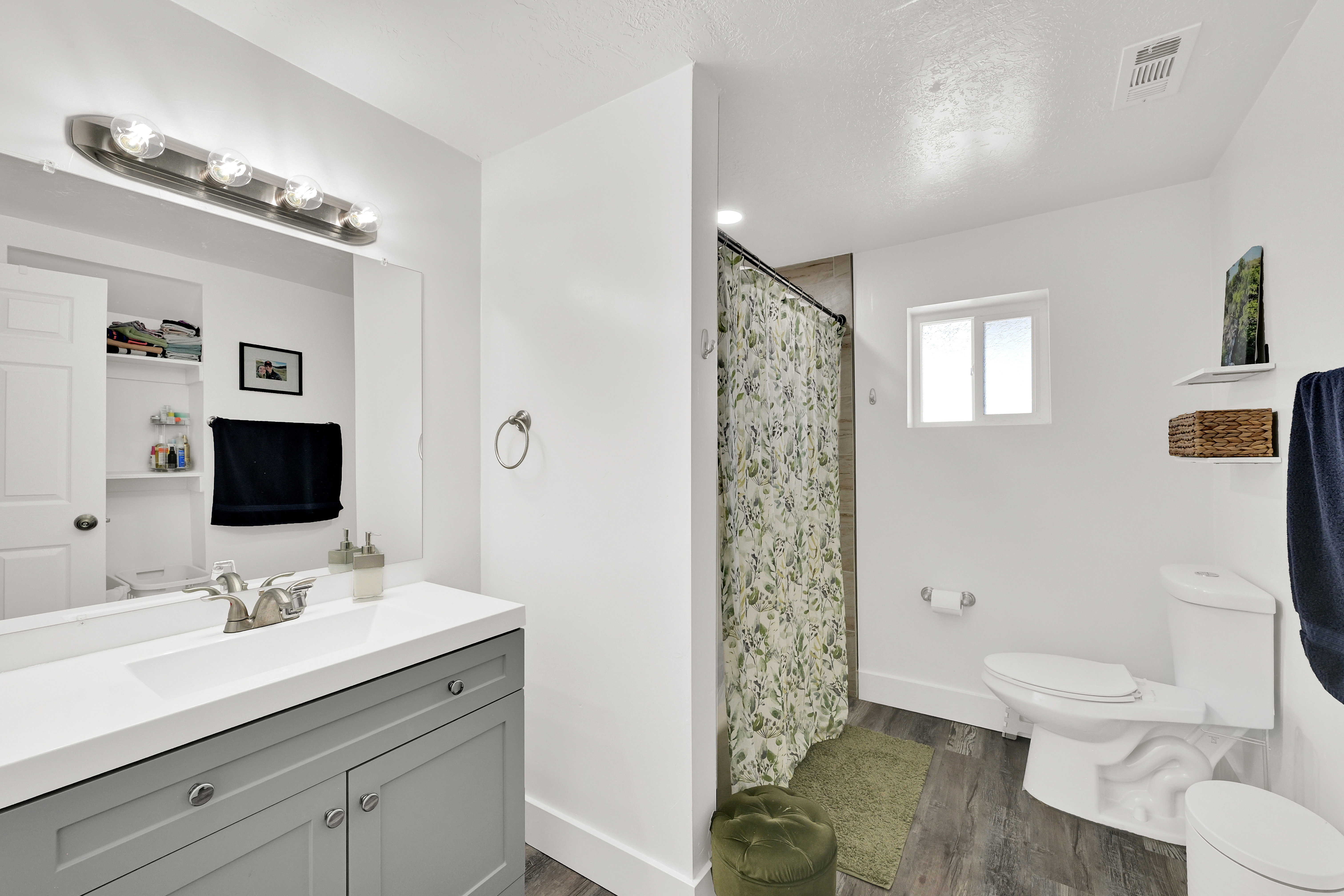 Bathroom featuring a single vanity with gray cabinetry, a white countertop, and a brushed nickel faucet