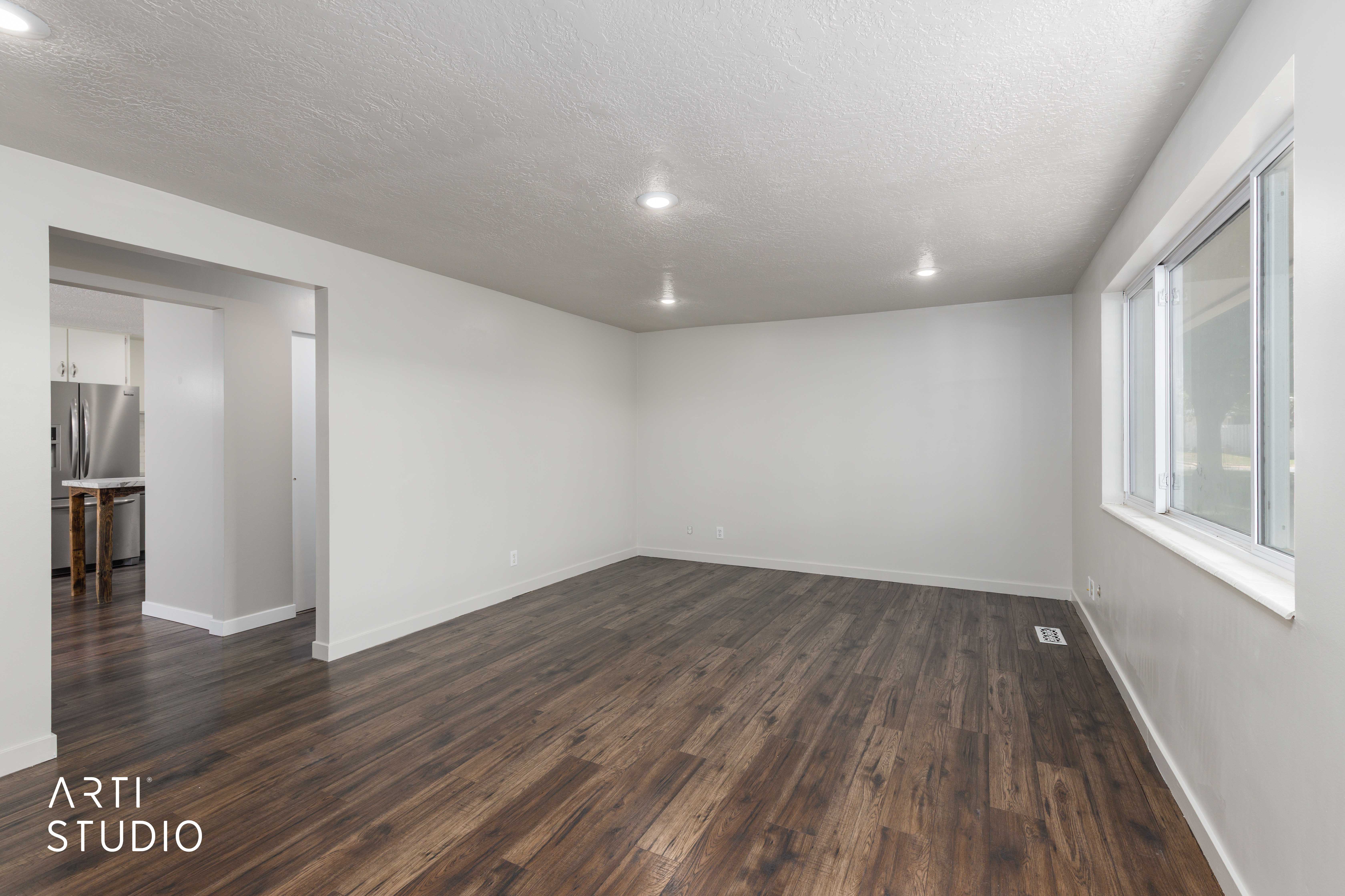 Spacious room featuring wood-finish flooring, recessed lighting, and white baseboards