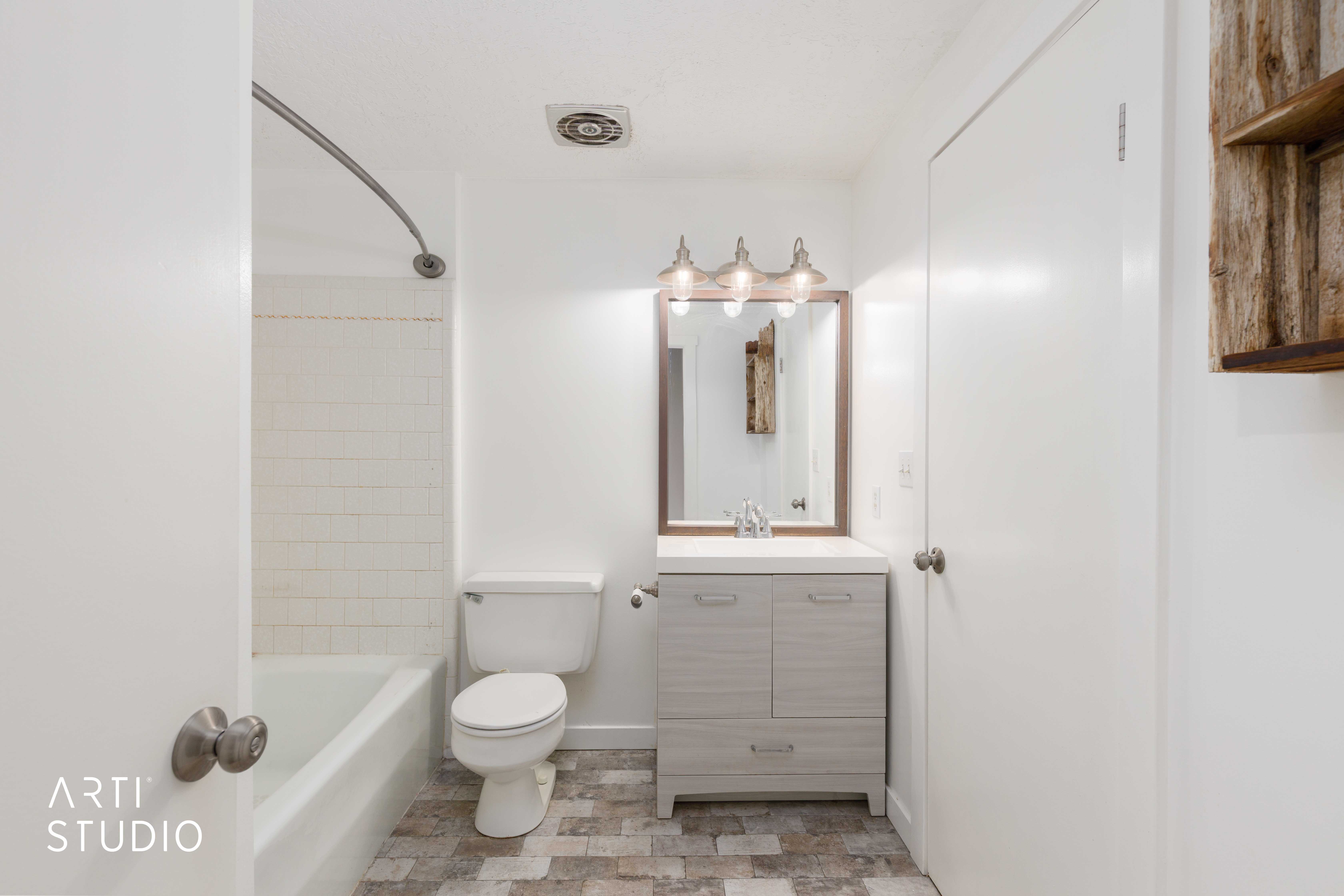 Bathroom featuring a white subway tile shower surround and an overhead ventilation fan