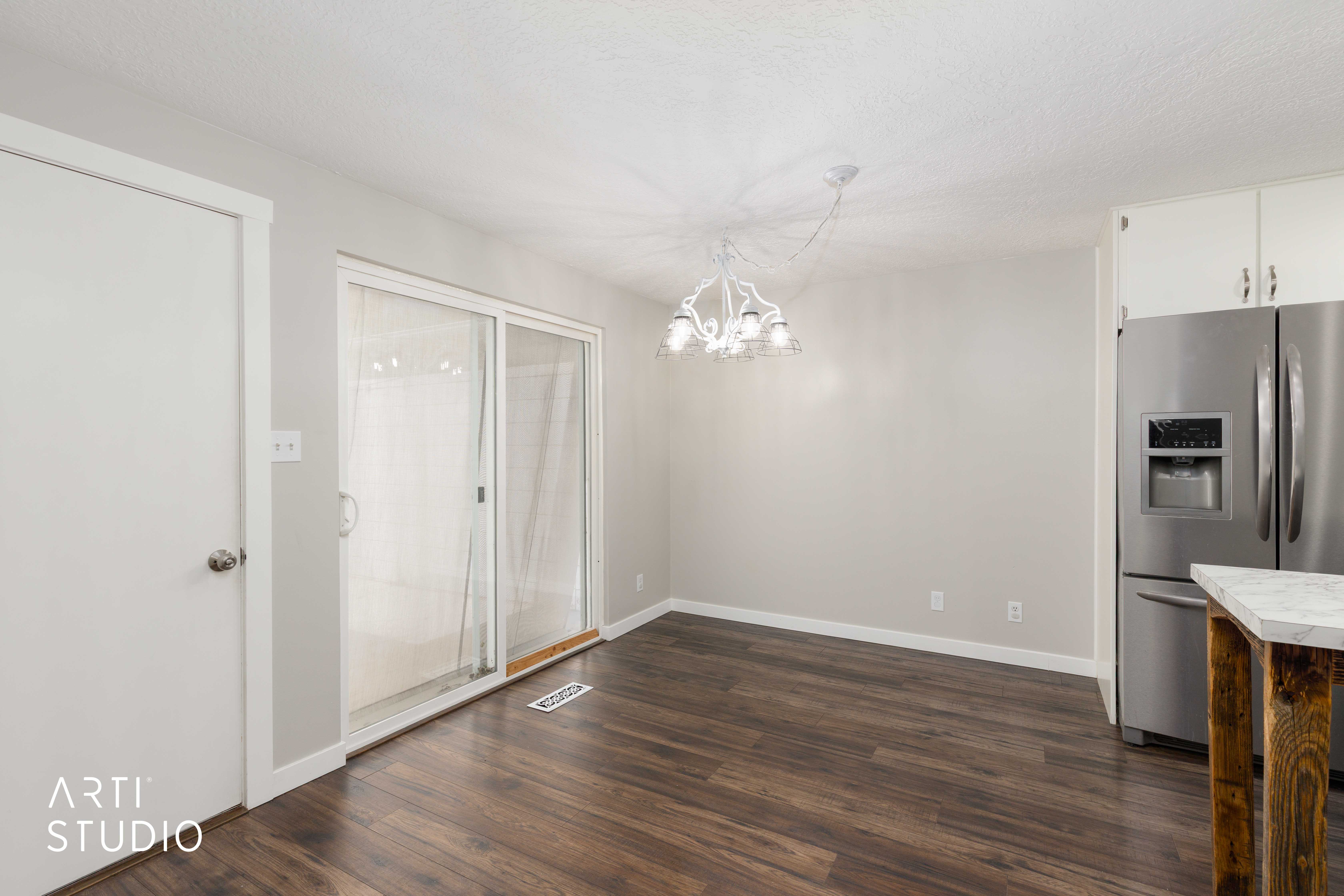 Dining area with wood-finish flooring, light grey wall paint, and a modern chandelier