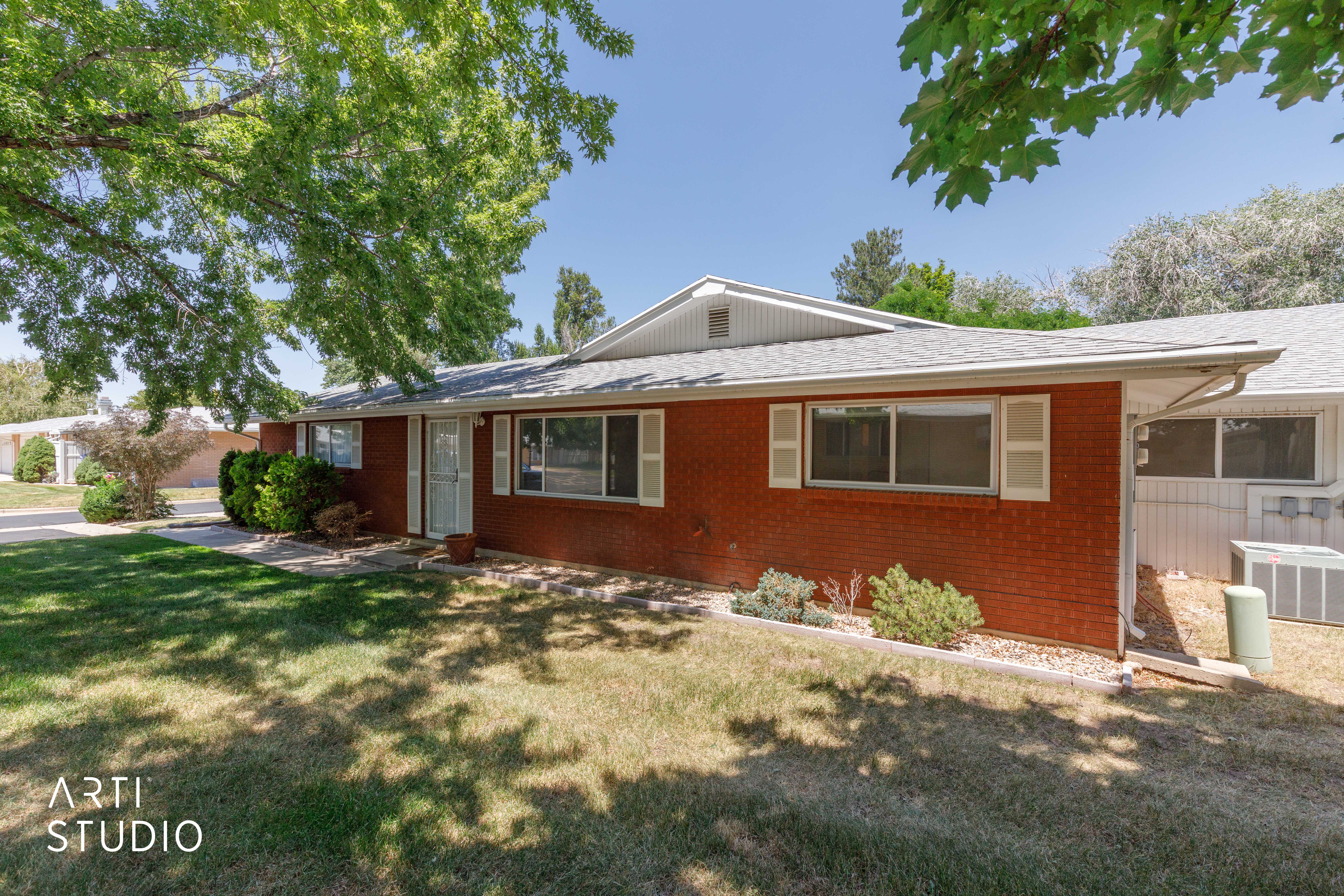 Red brick exterior with white shutter accents and a light gray shingle roof