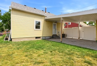 Covered patio with a paved driveway and privacy fencing