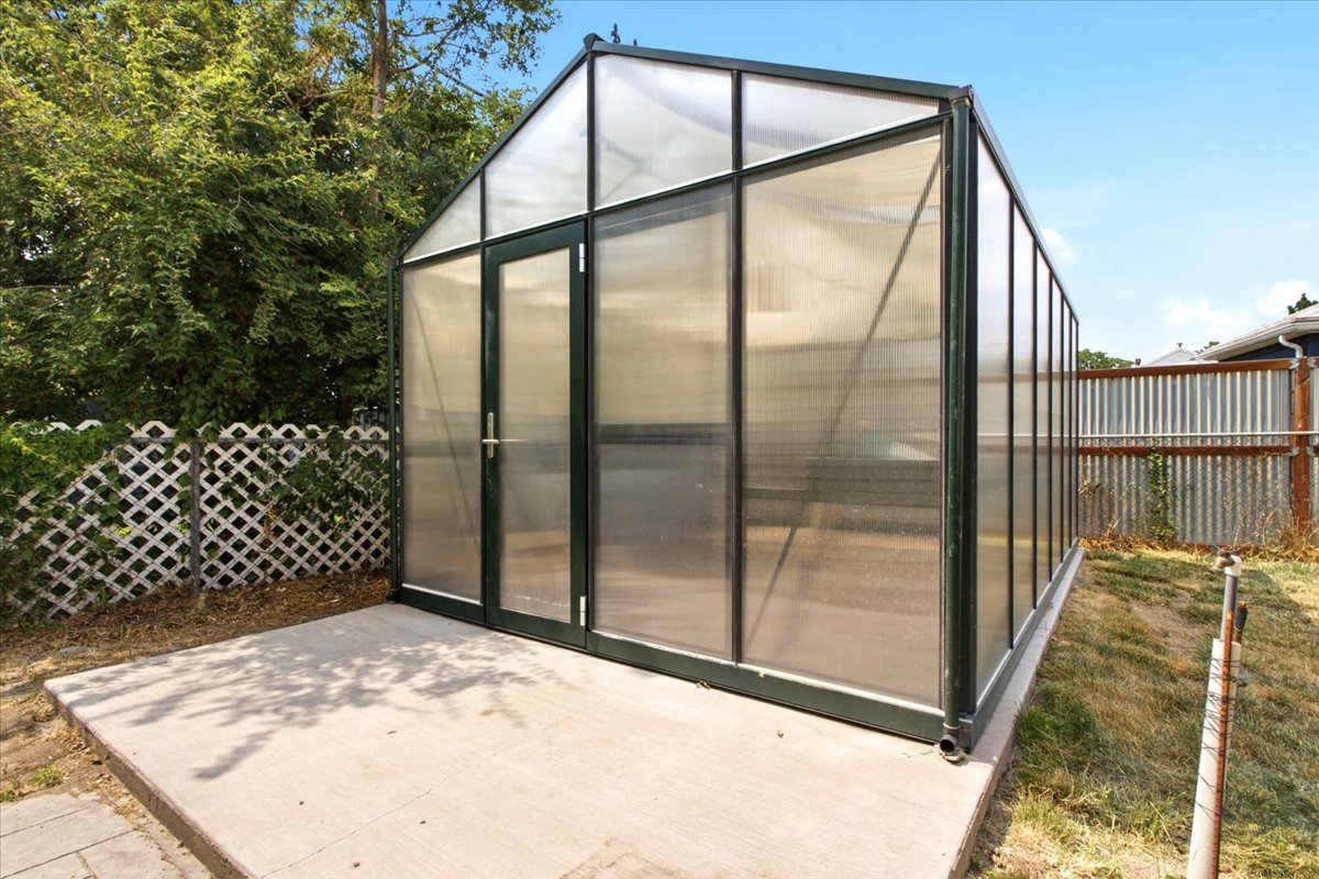 Freestanding greenhouse structure featuring a metal frame and translucent panels