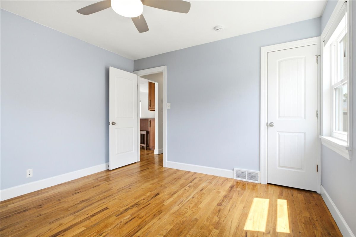 Wood-finish flooring throughout, complemented by light blue wall tones and white baseboards