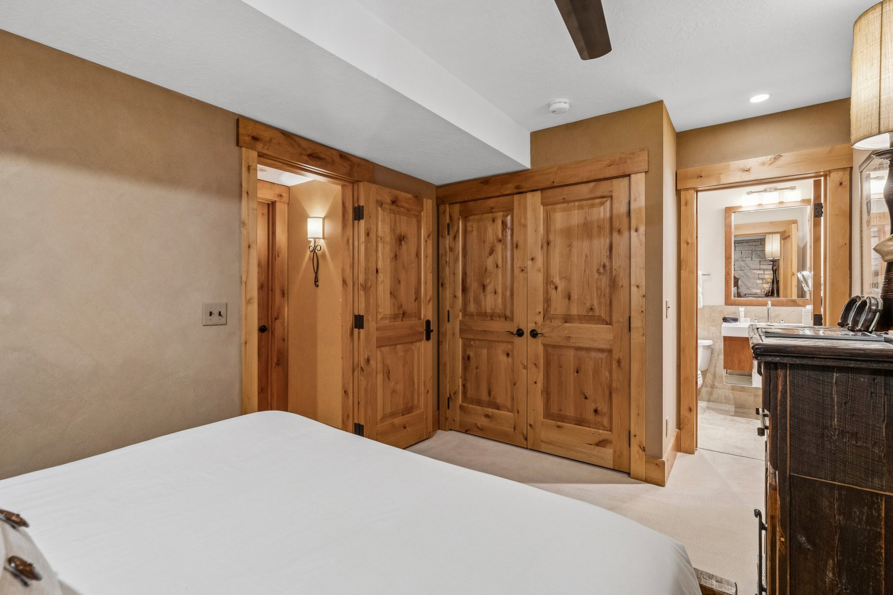Bedroom featuring knotty wood doors, trim, and a ceiling fan