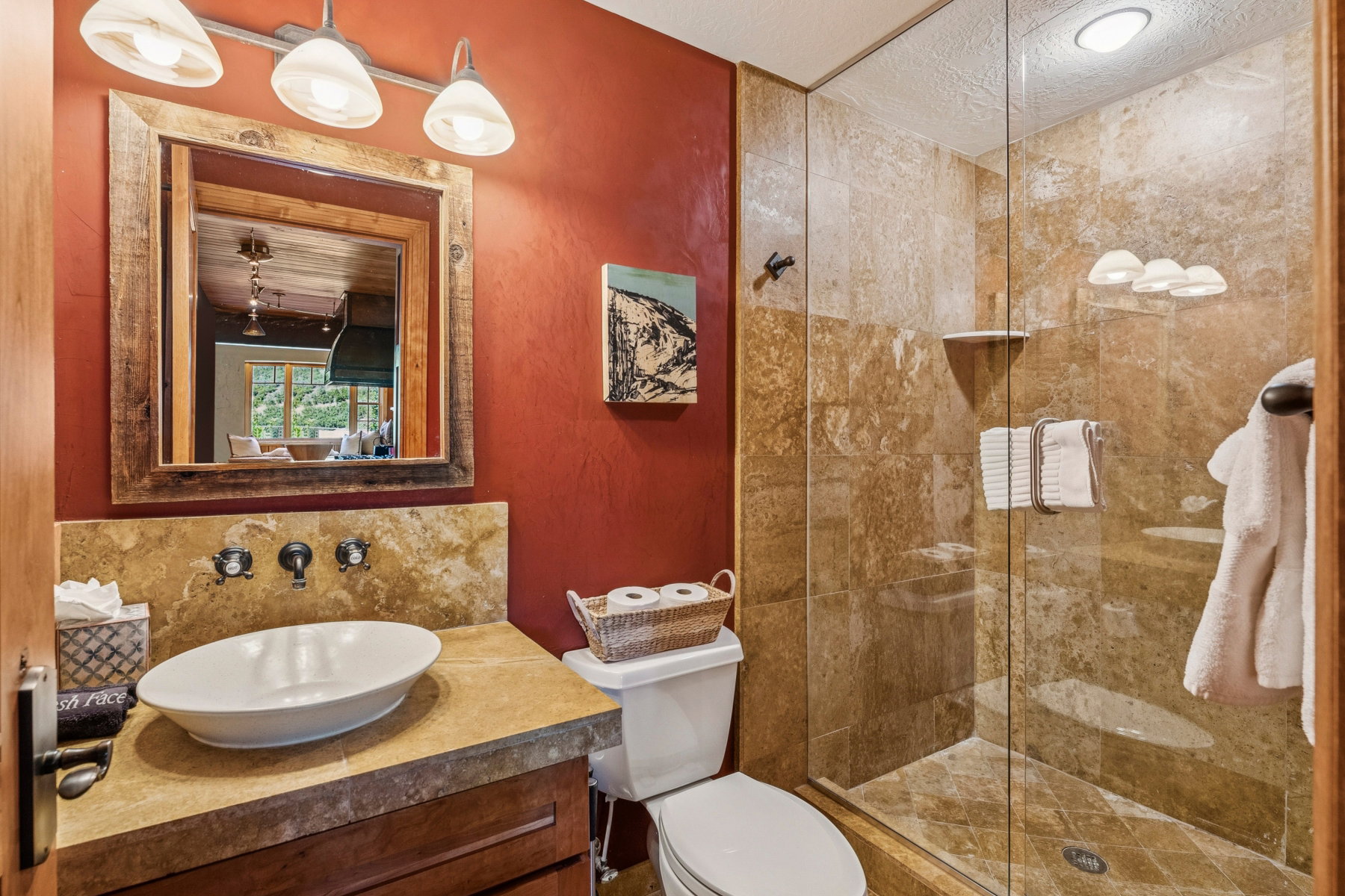 Bathroom featuring a walk-in shower with full-height stone tile surround and glass enclosure