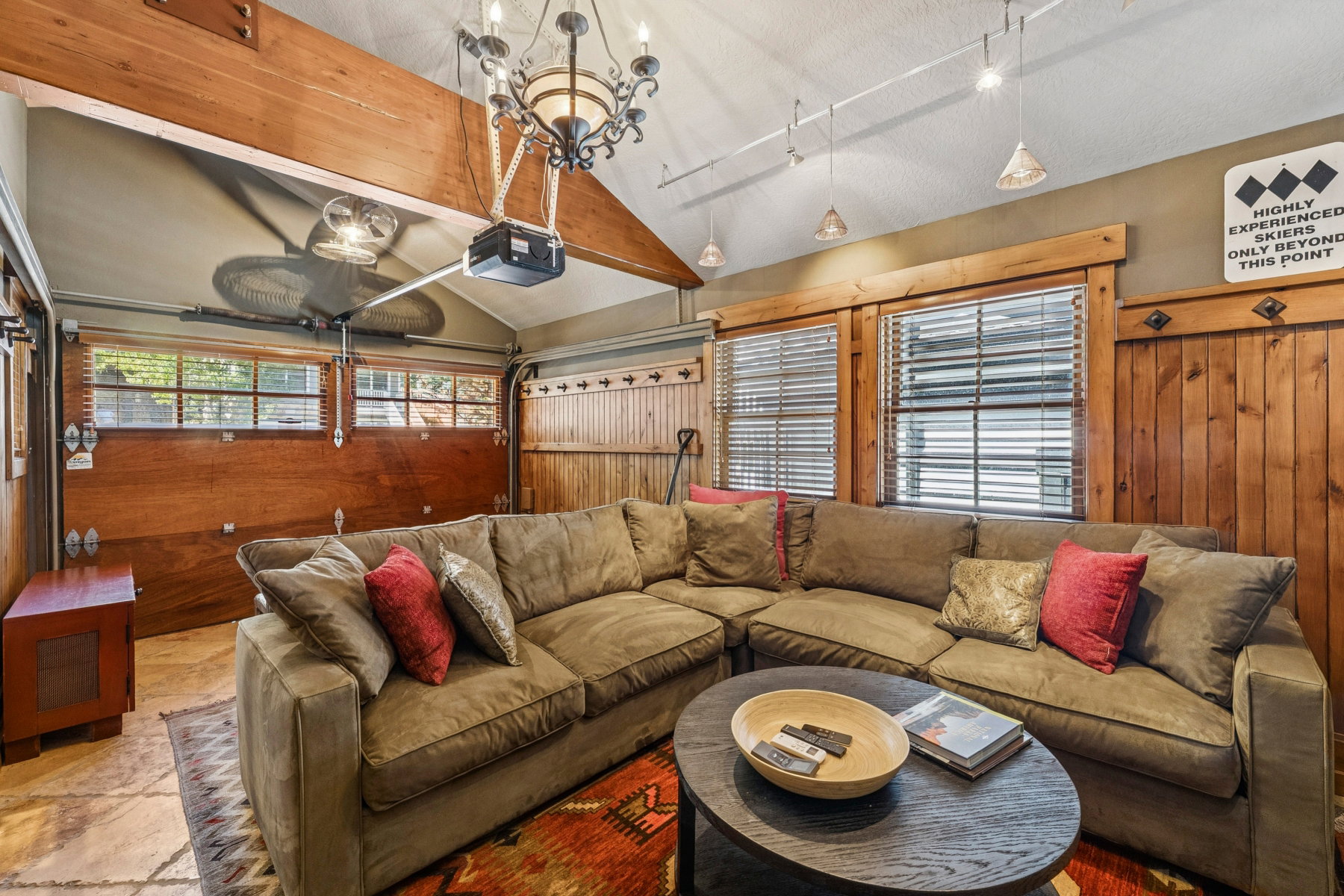 Vaulted ceiling with exposed wood beam and chandelier lighting