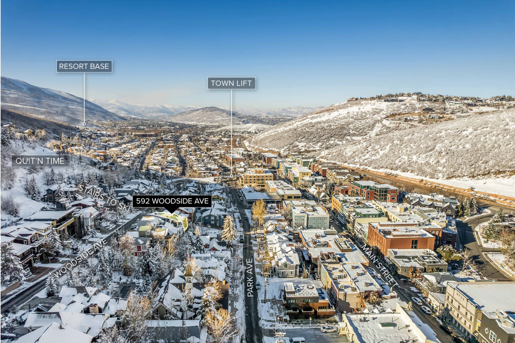 Aerial perspective of a snow-covered mountain town featuring a prominent main street