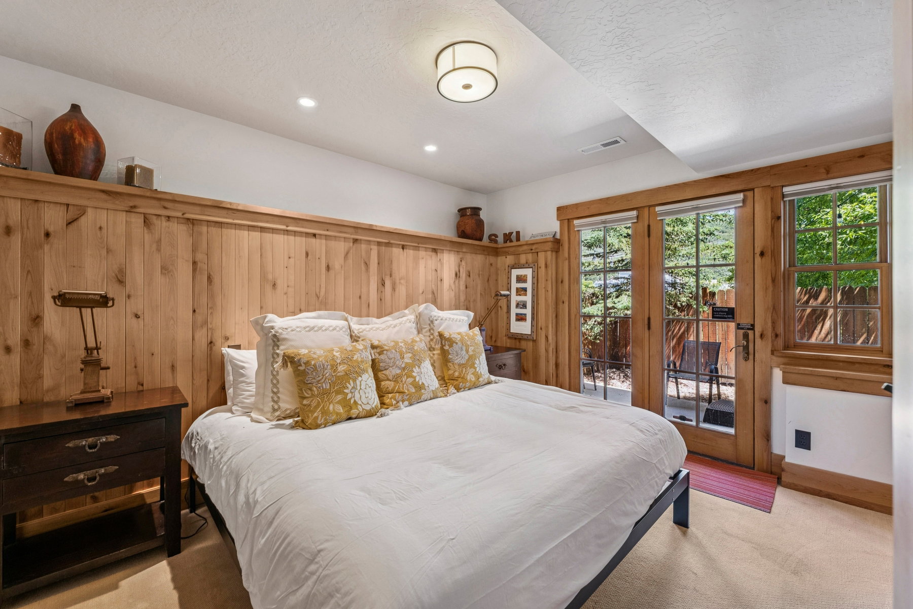 Bedroom featuring wood-panel wainscoting with an integrated display shelf, recessed lighting, and a flush-mount ceiling fixture