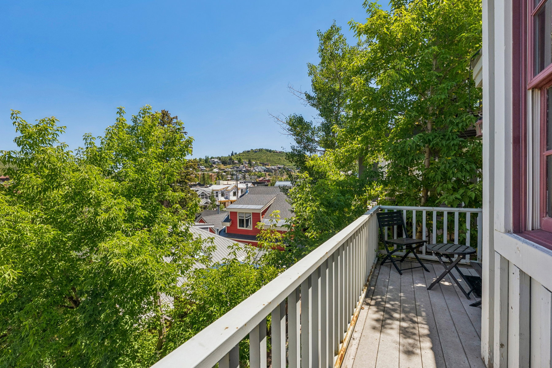 Outdoor balcony featuring wood decking and a white painted railing