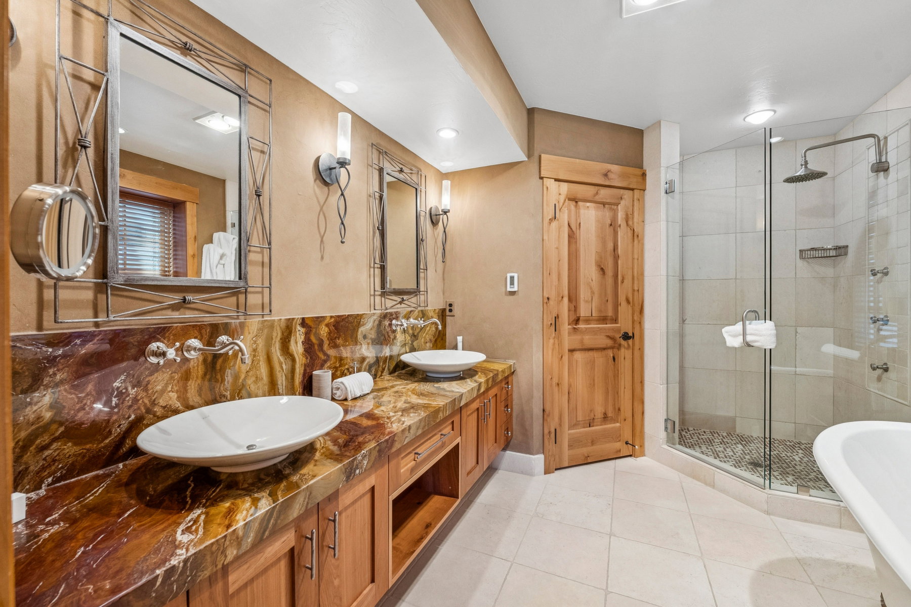 Double vanity with vessel sinks, stone countertop, and wall-mounted faucets