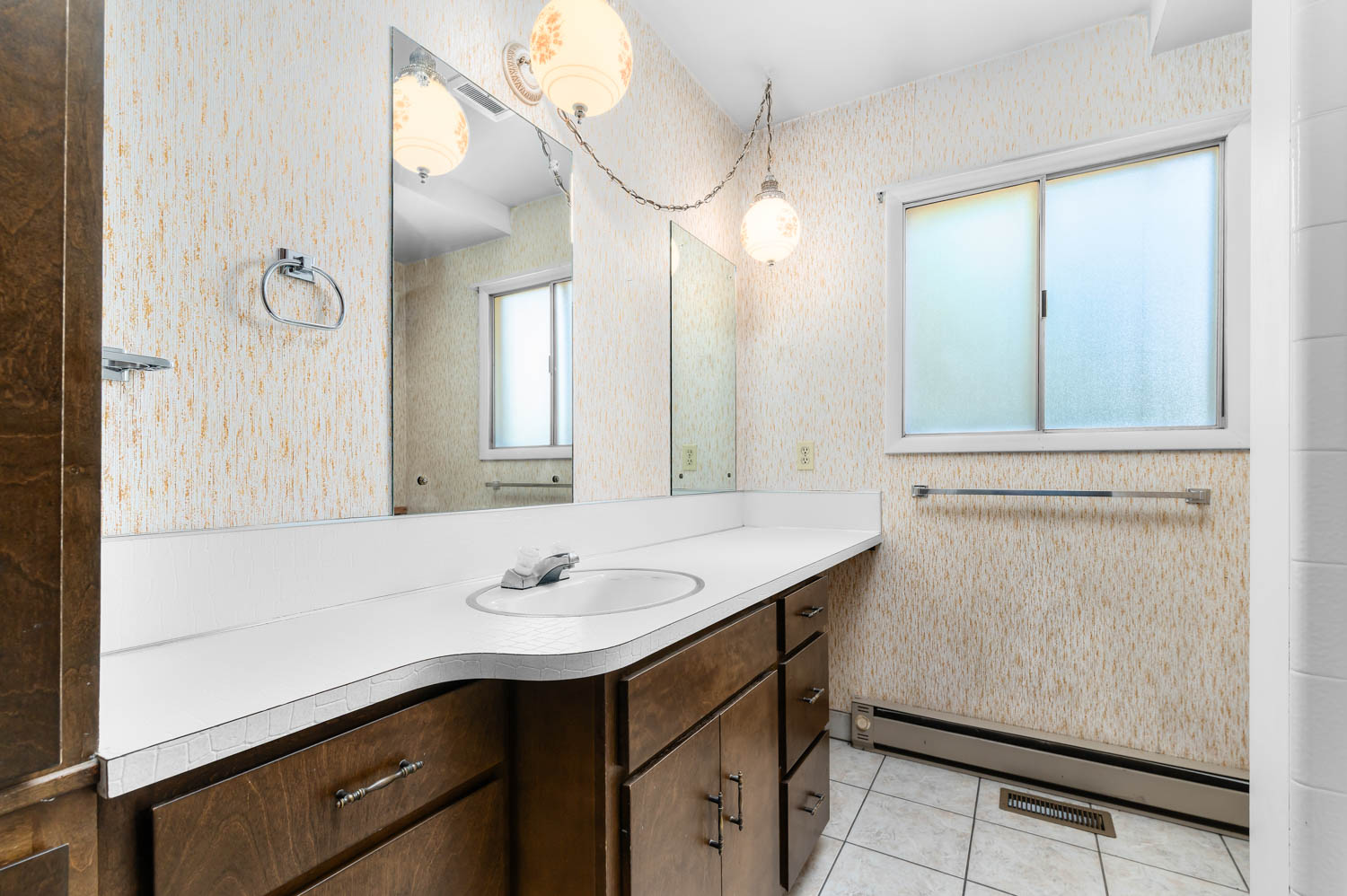 Bathroom vanity featuring an integrated sink with a single-handle faucet, wood-finish cabinetry, and a countertop with an organic edge