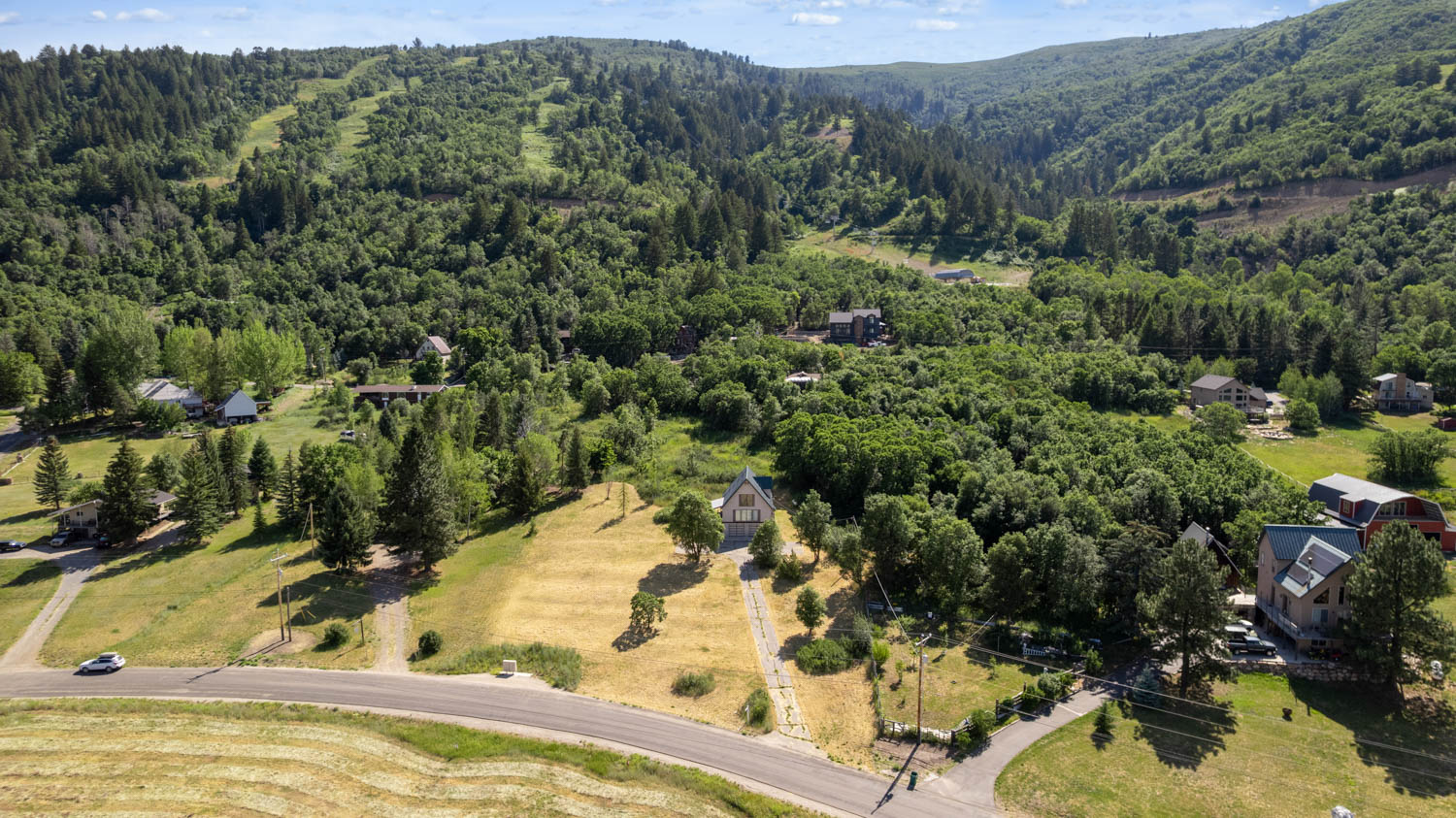 Expansive land parcel featuring a main road frontage, verdant surroundings, and distant mountain vistas