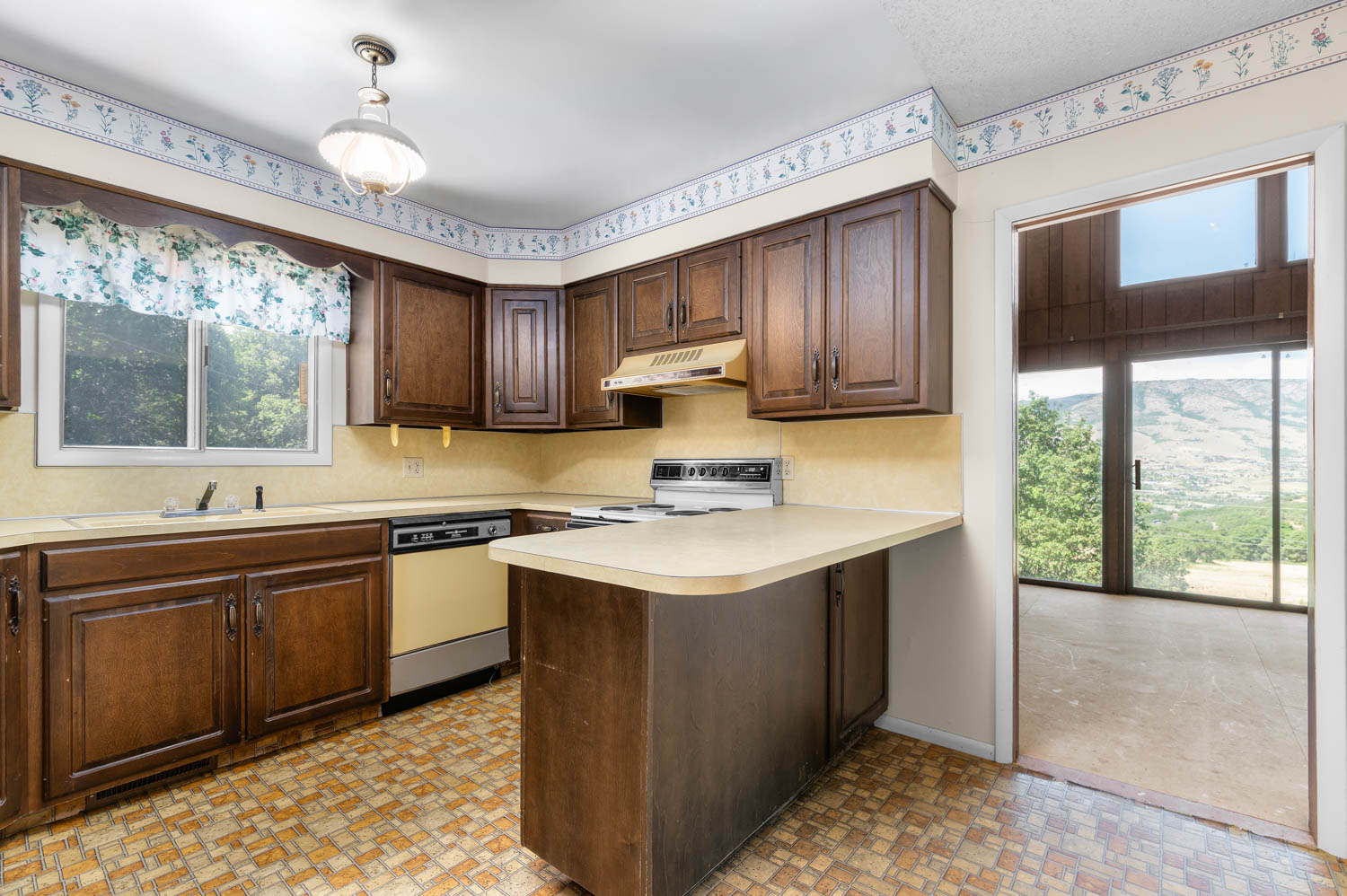 Kitchen featuring wood cabinetry, laminate countertops, and a built-in electric range